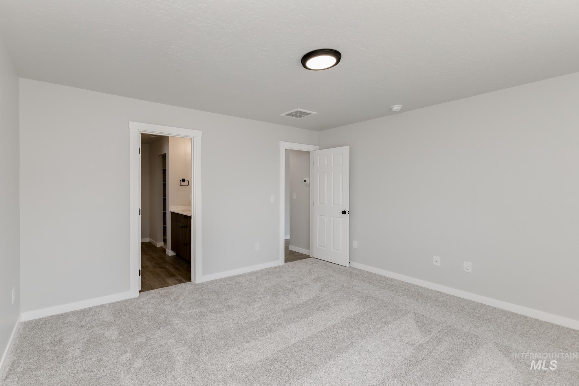 Unfurnished bedroom with carpet flooring and ensuite bath