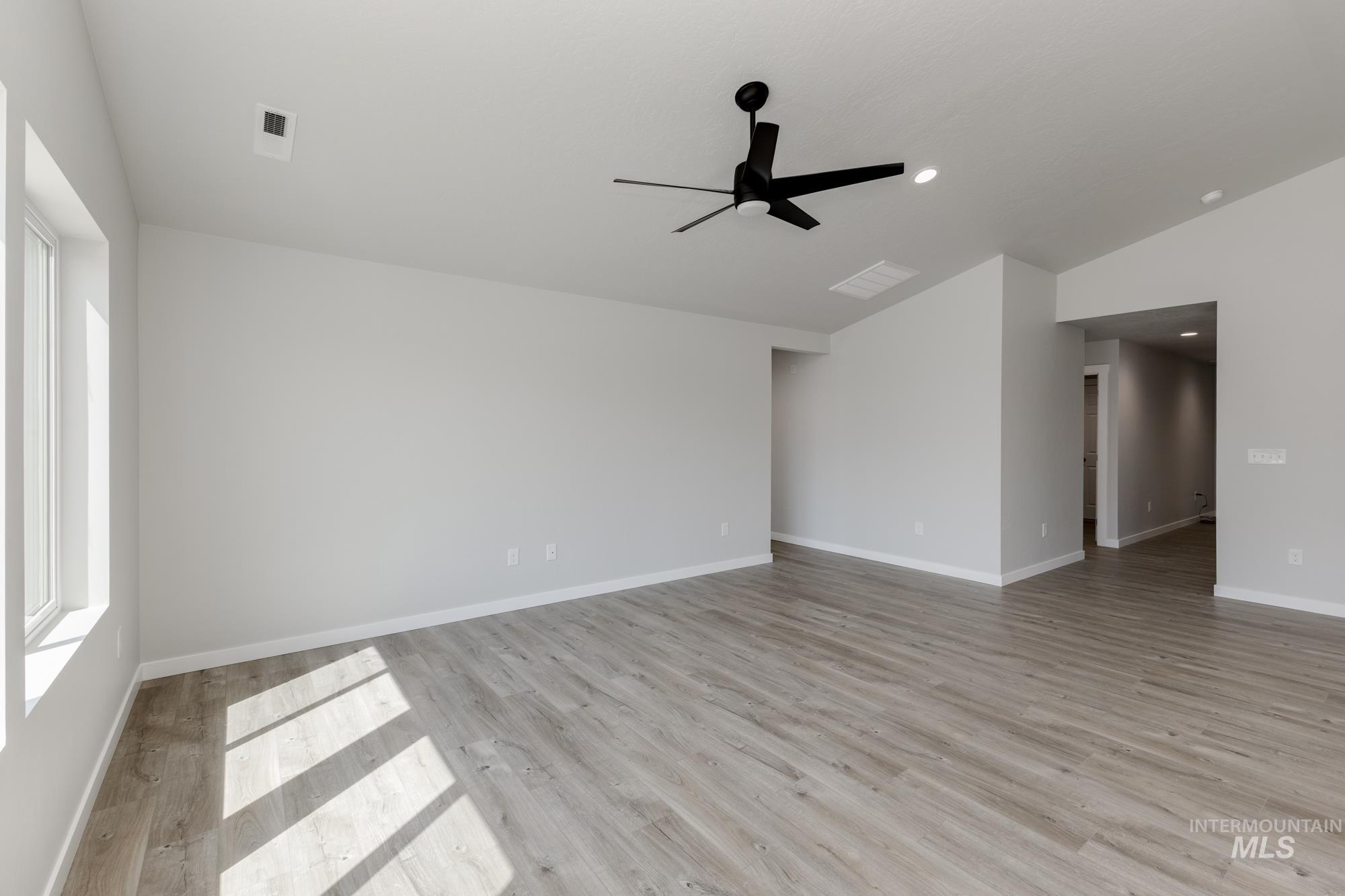 Empty room featuring lofted ceiling, light wood-type flooring, ceiling fan, and recessed lighting