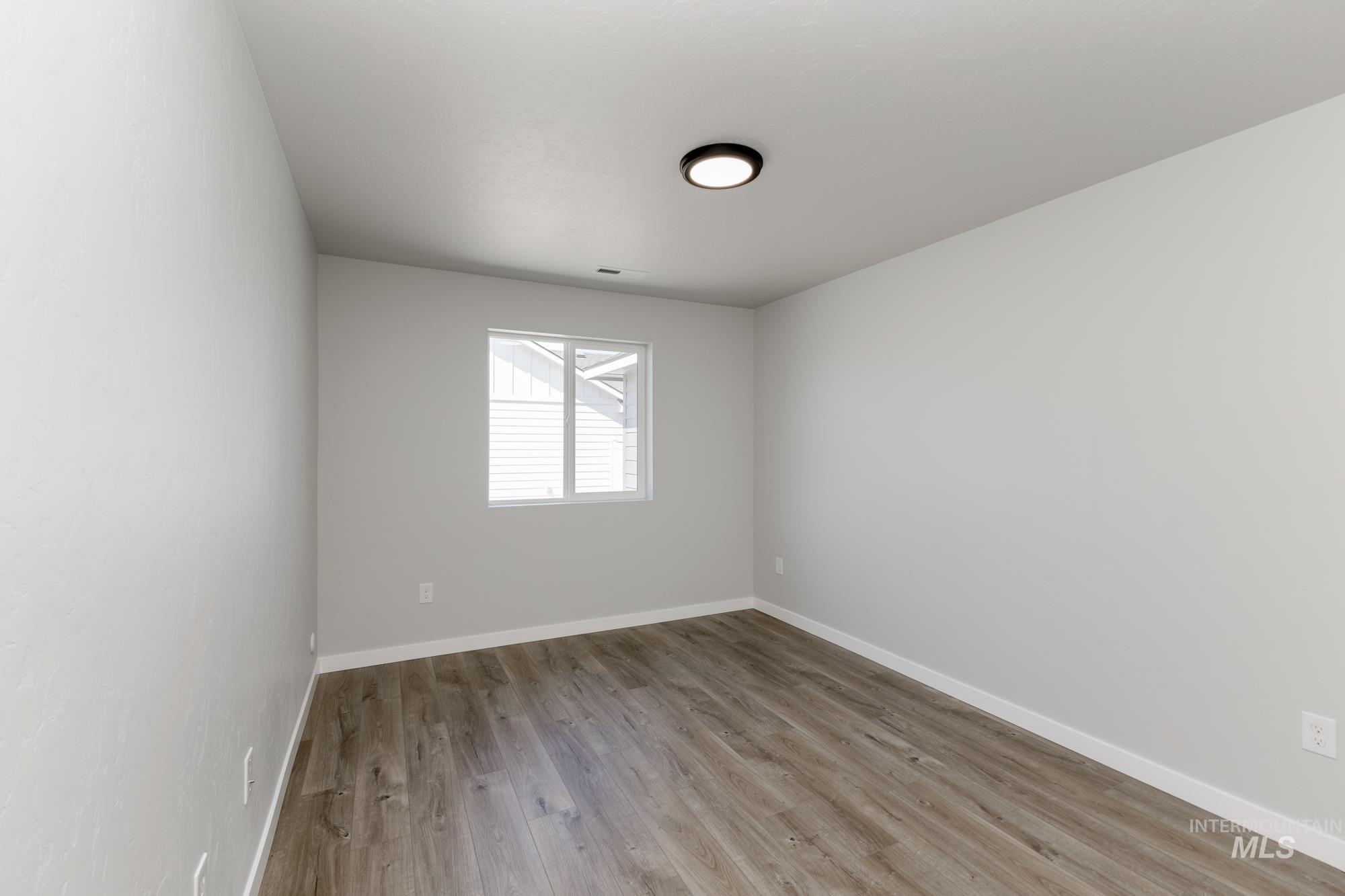 Unfurnished room with light wood finished floors and baseboards