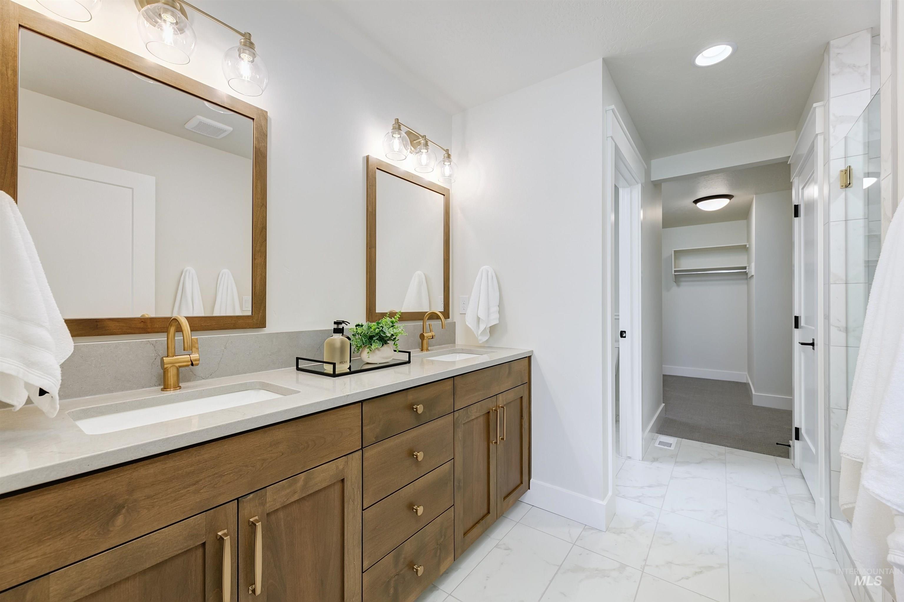 Bathroom with double vanity, a walk in closet, light marble finish flooring, recessed lighting, and curtained shower
