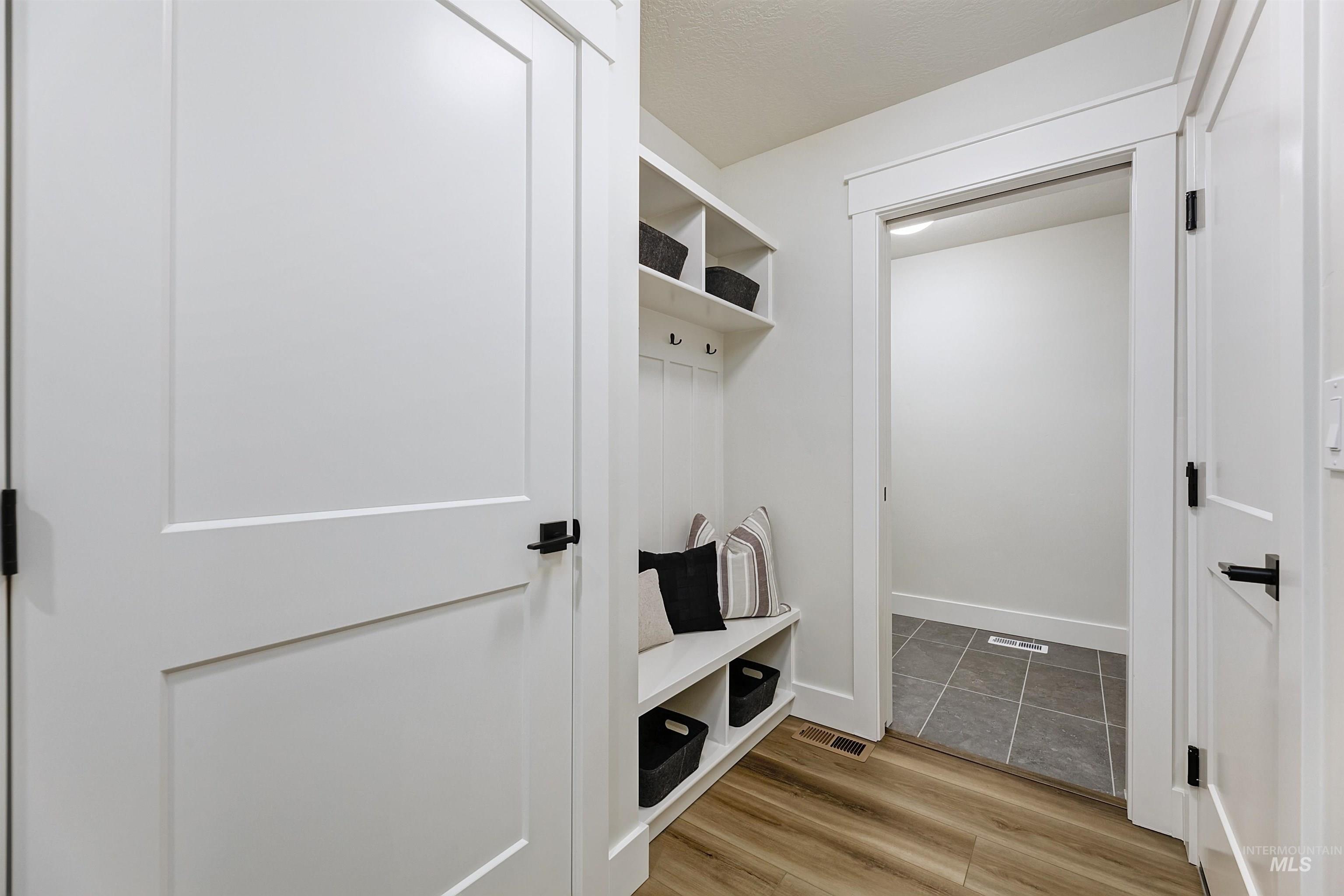 Mudroom with light wood-style flooring and baseboards