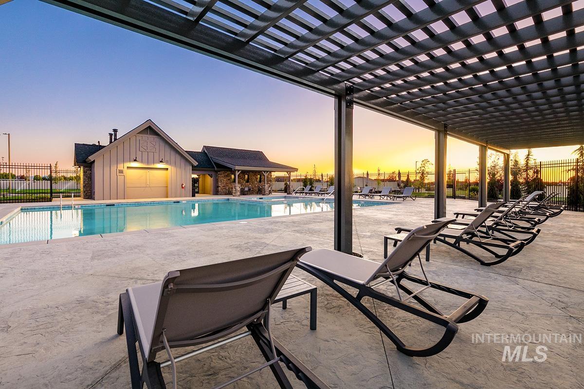Pool at dusk featuring a patio, a community pool, and a pergola