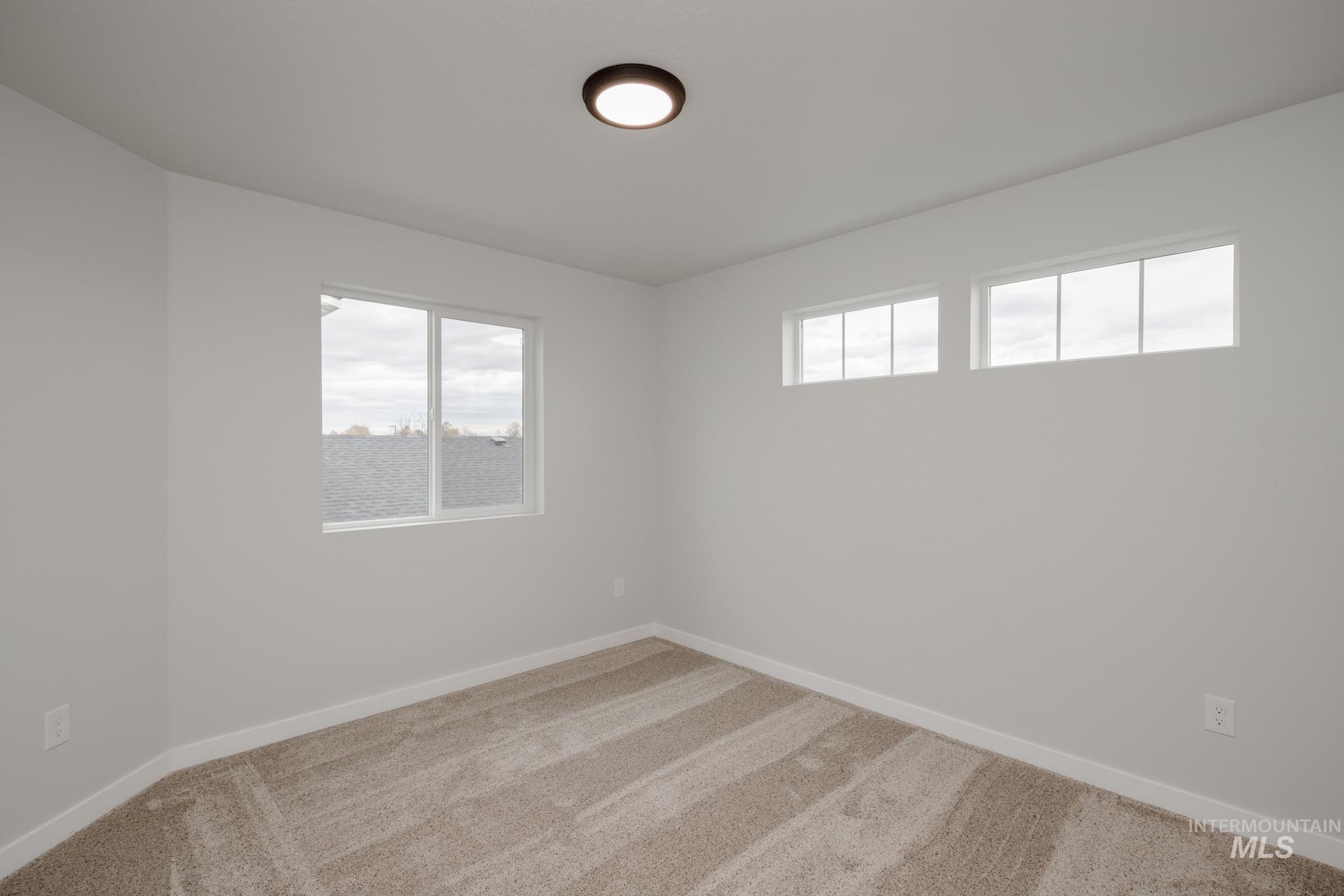 Carpeted empty room with healthy amount of natural light