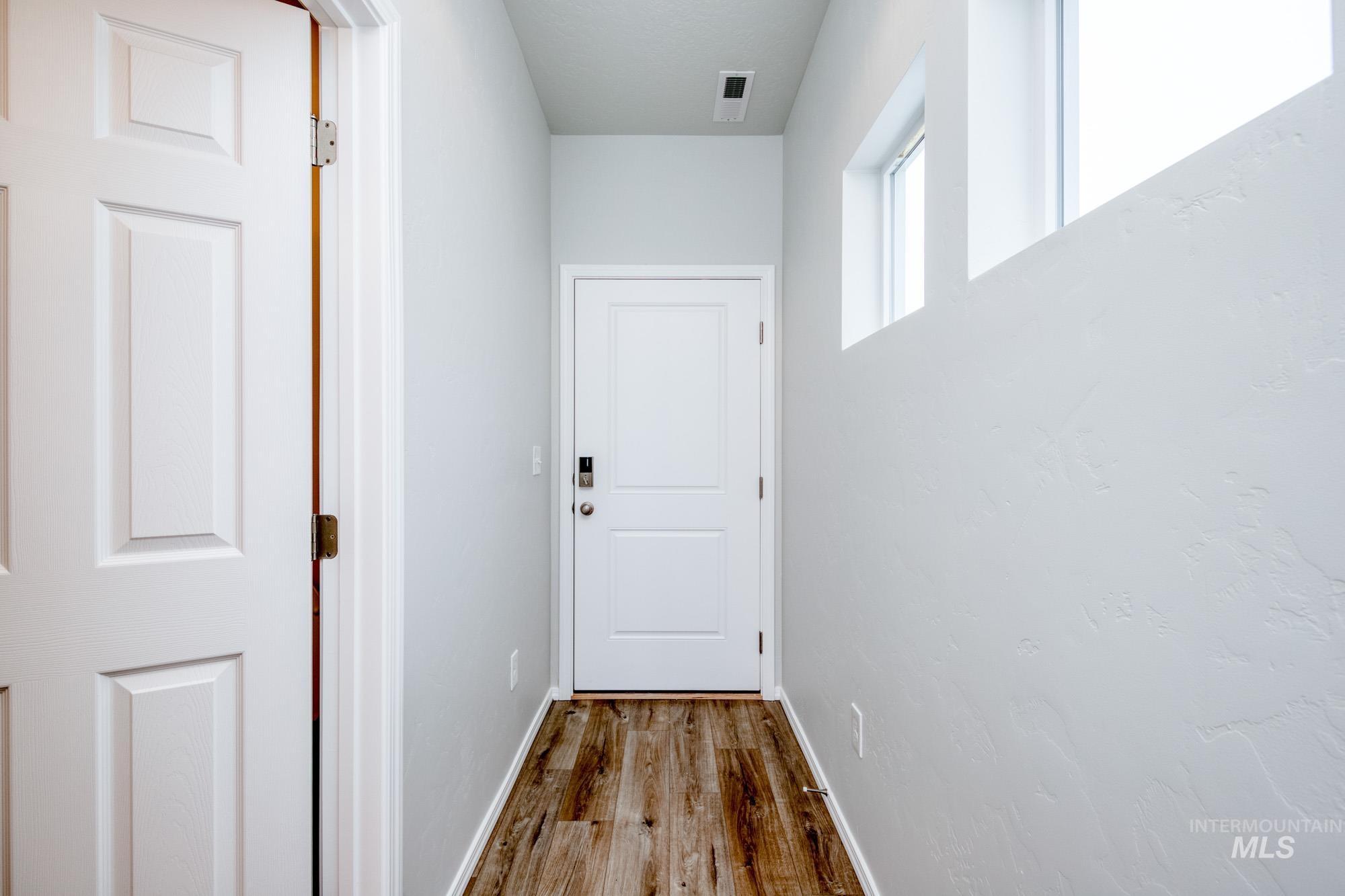 Hallway featuring wood finished floors and baseboards