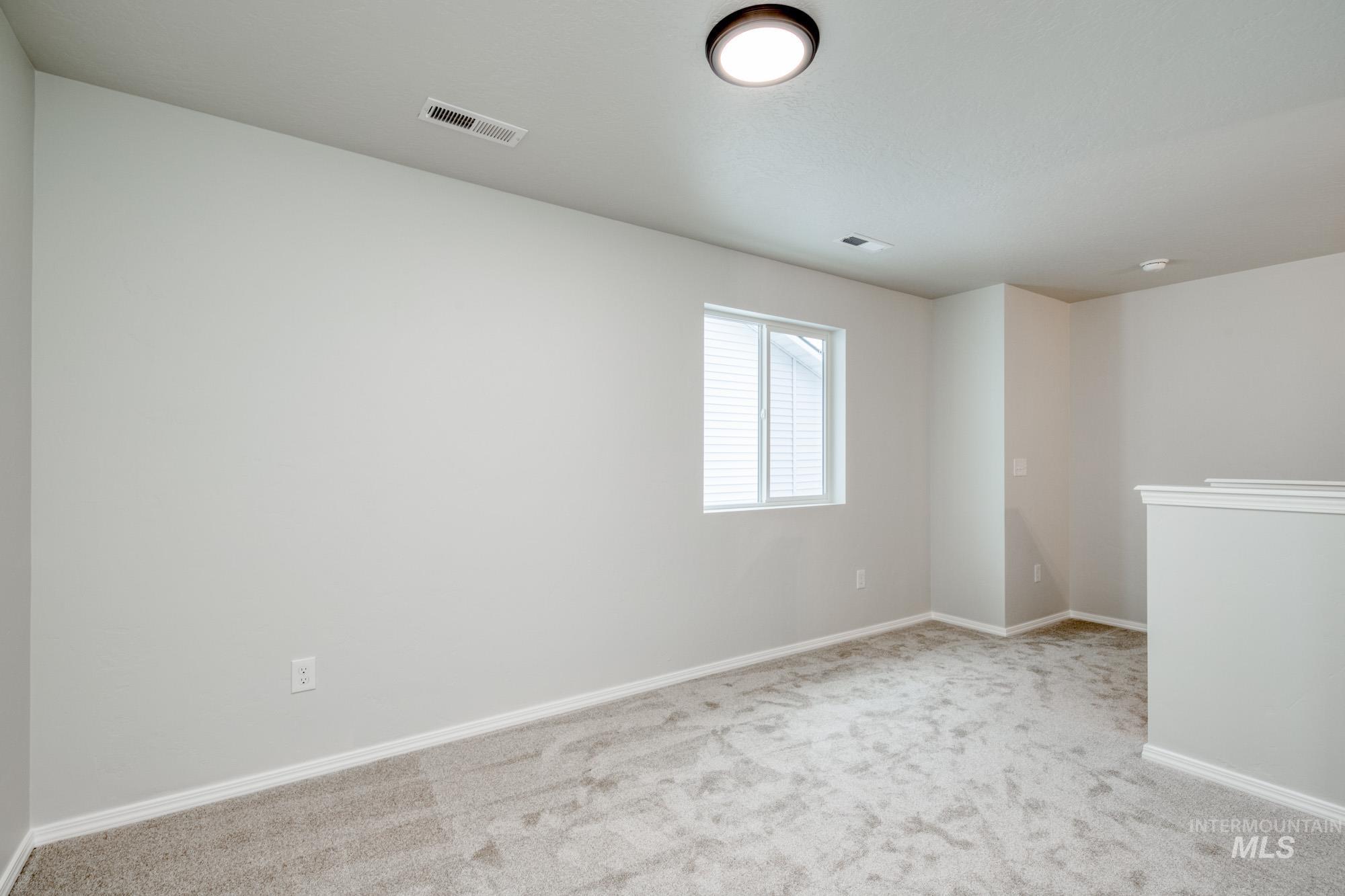 Carpeted spare room with baseboards