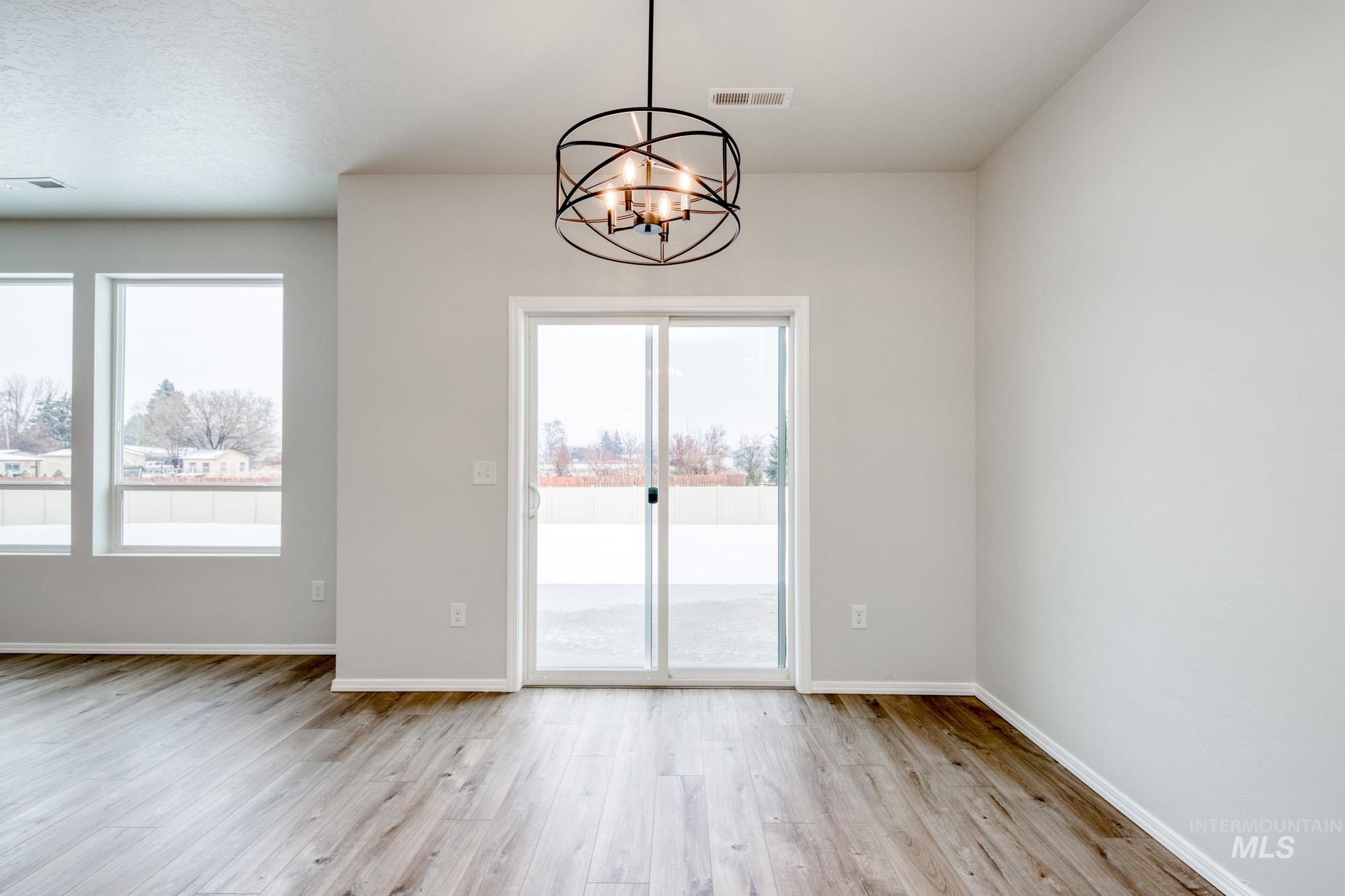 Unfurnished dining area featuring light wood-style flooring and a chandelier