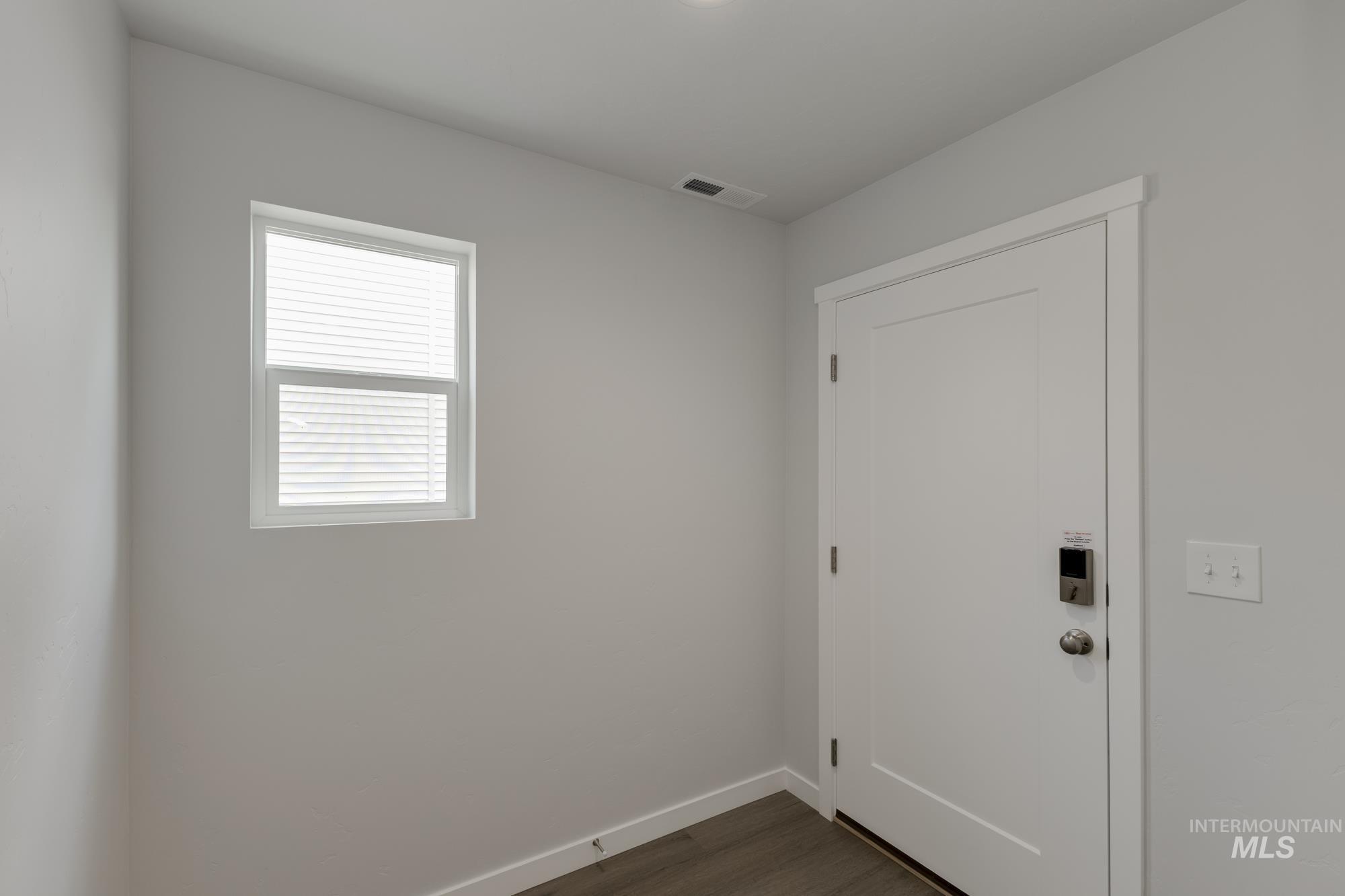 Doorway to outside with baseboards and wood finished floors