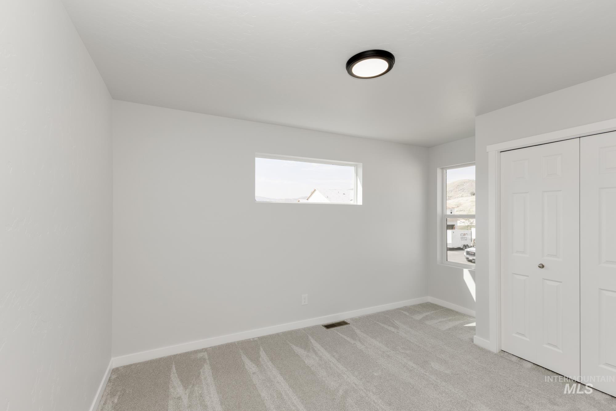 Unfurnished bedroom featuring light carpet and a closet