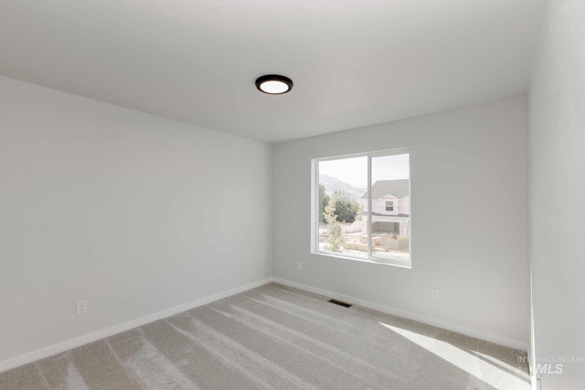 Carpeted empty room featuring baseboards