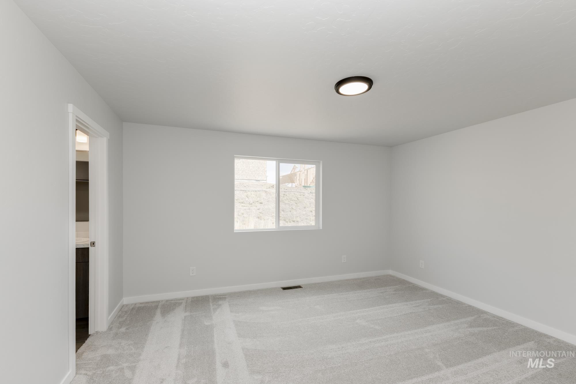 Unfurnished room with light carpet and baseboards