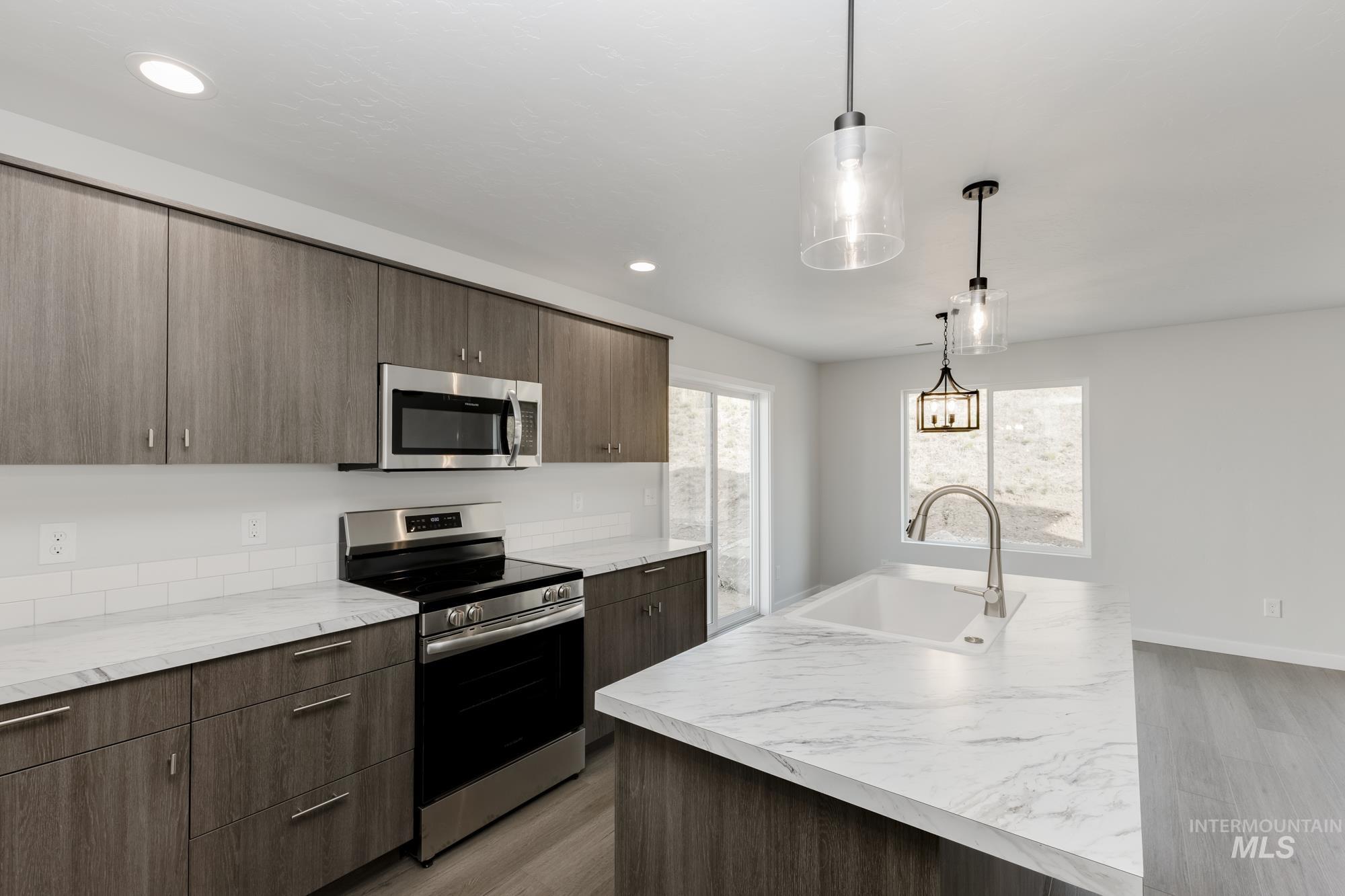 Kitchen featuring appliances with stainless steel finishes, light wood-style floors, light countertops, and recessed lighting