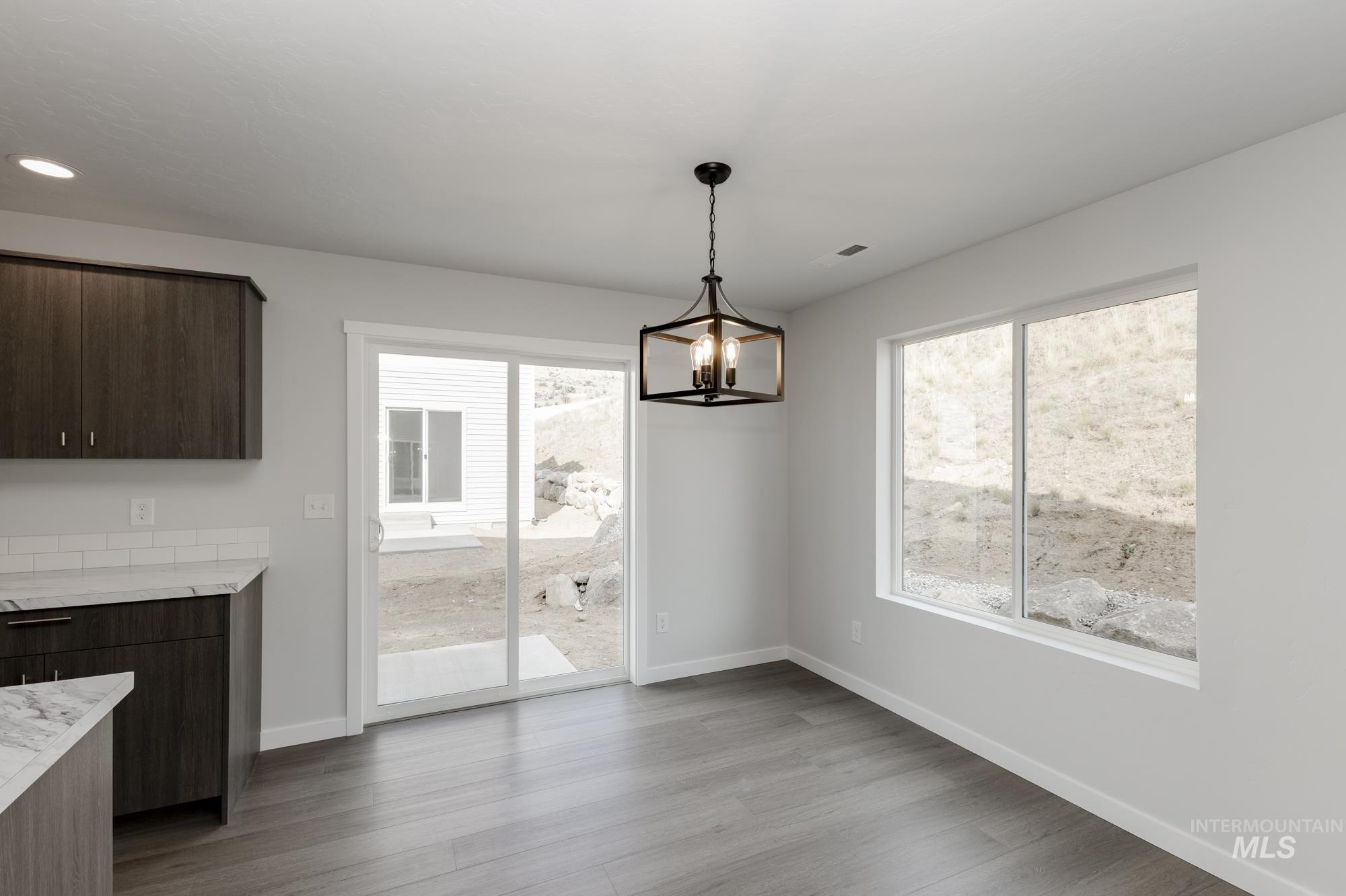 Unfurnished dining area with light wood-style flooring, plenty of natural light, a chandelier, and recessed lighting