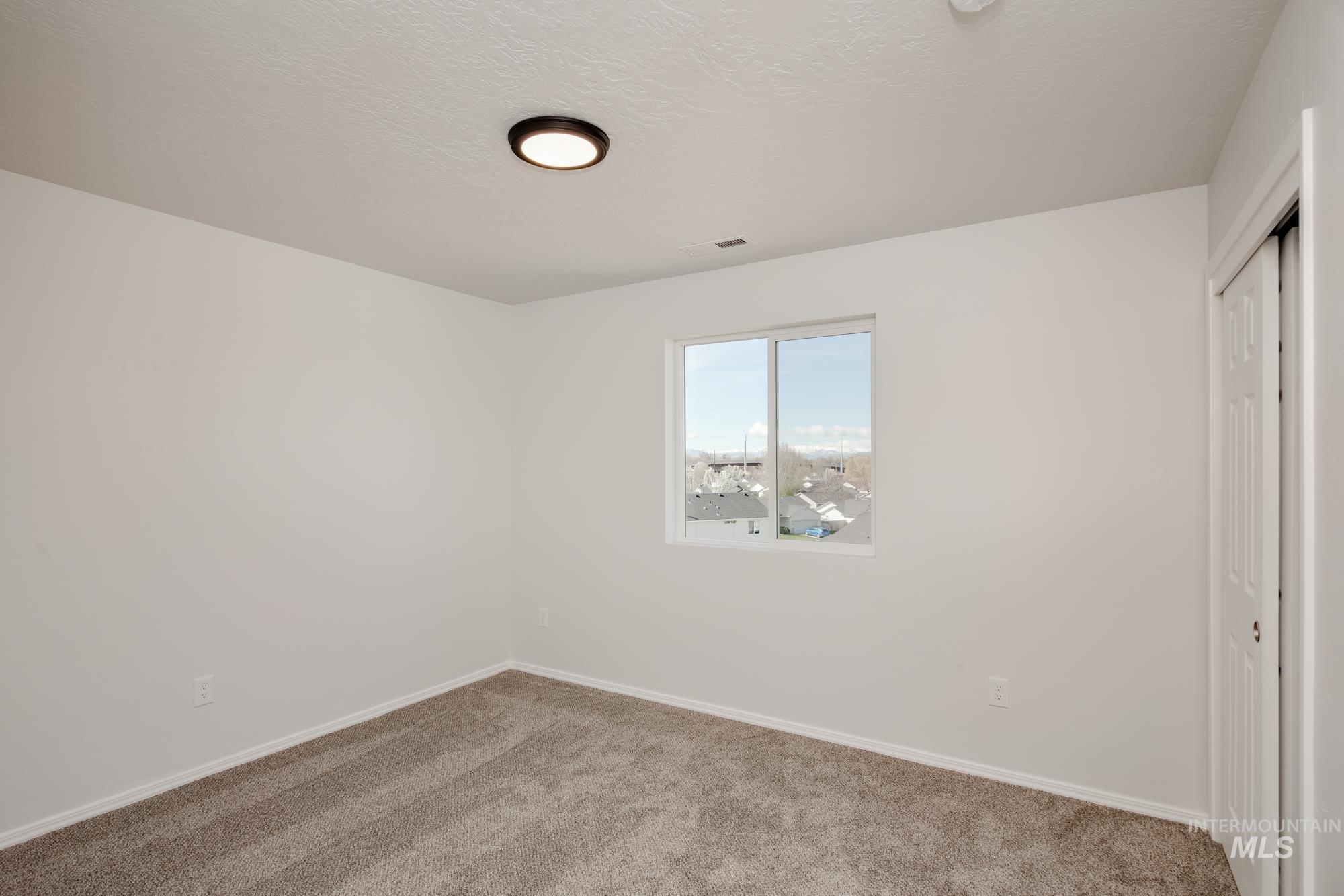Unfurnished bedroom featuring a closet, carpet floors, and a textured ceiling