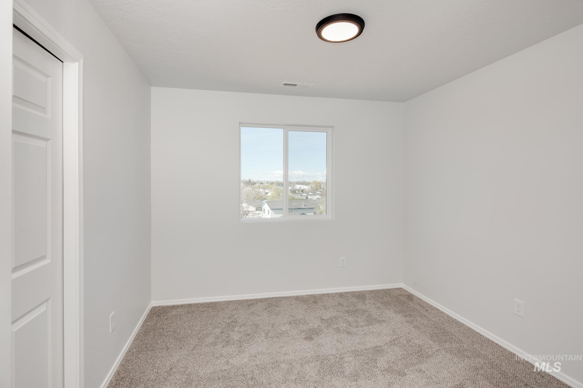 Empty room featuring carpet and baseboards