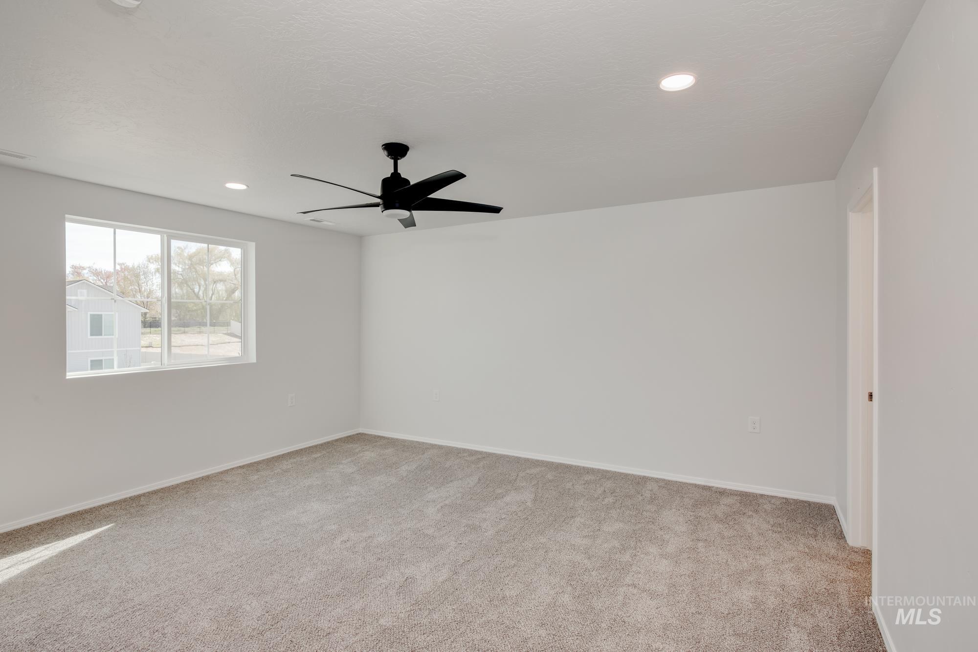 Spare room featuring light colored carpet, ceiling fan, and recessed lighting