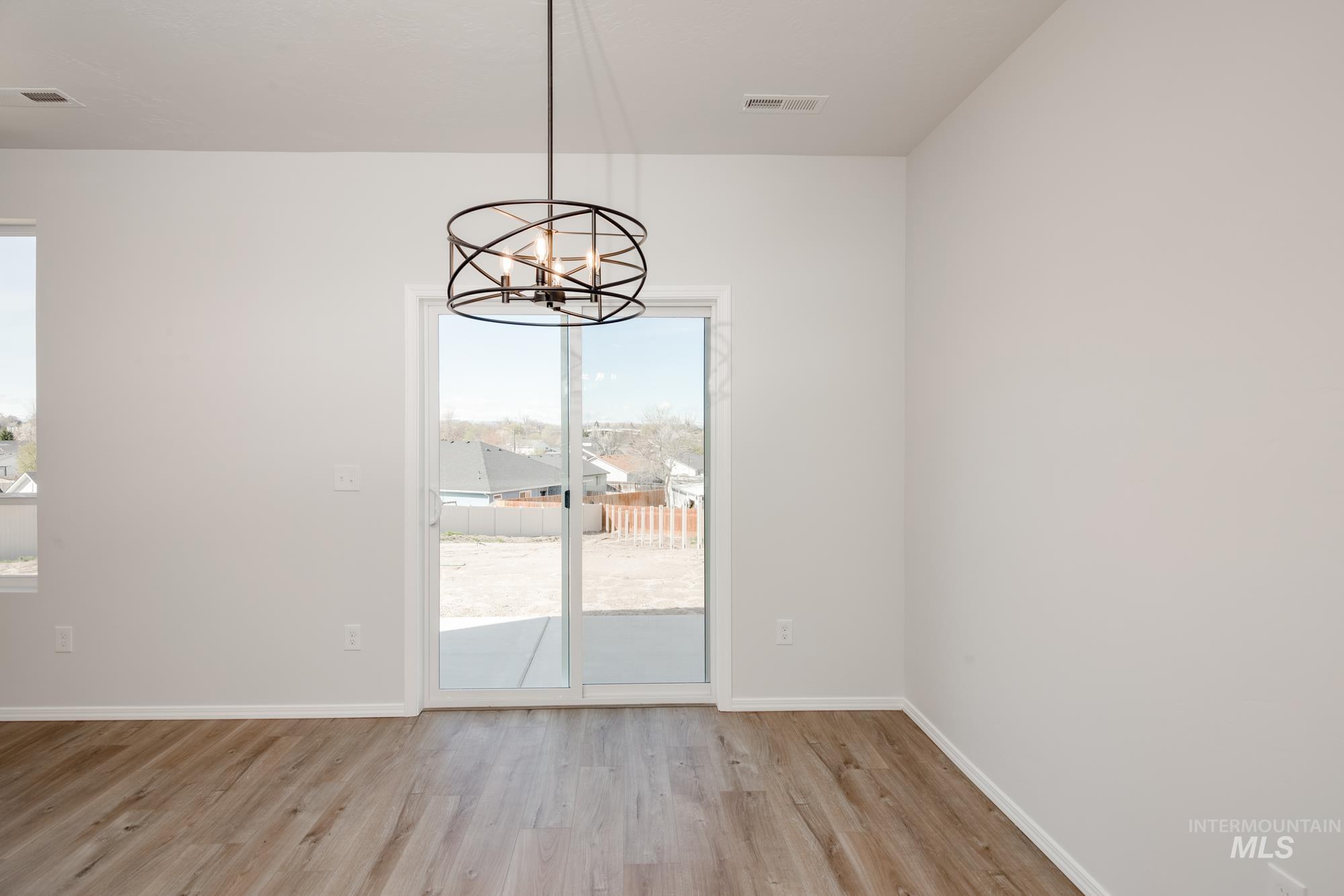Unfurnished dining area with light wood finished floors and a chandelier