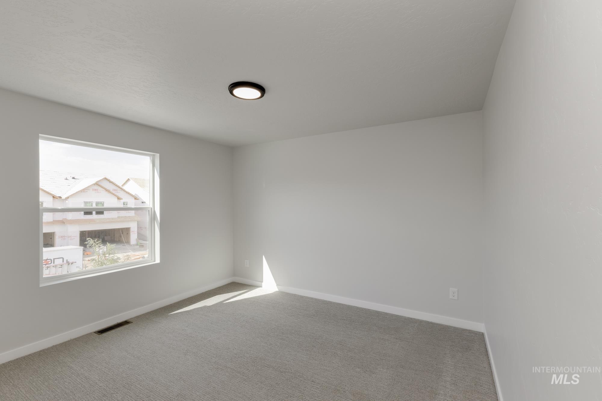 Carpeted empty room featuring baseboards