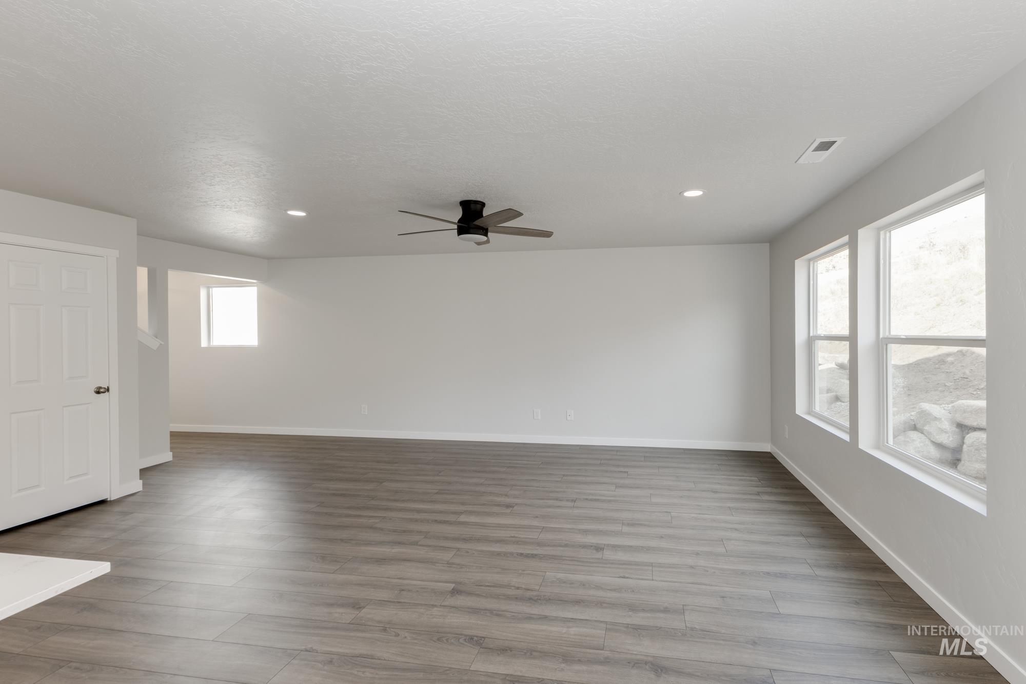 Spare room with light wood-style floors, ceiling fan, and recessed lighting