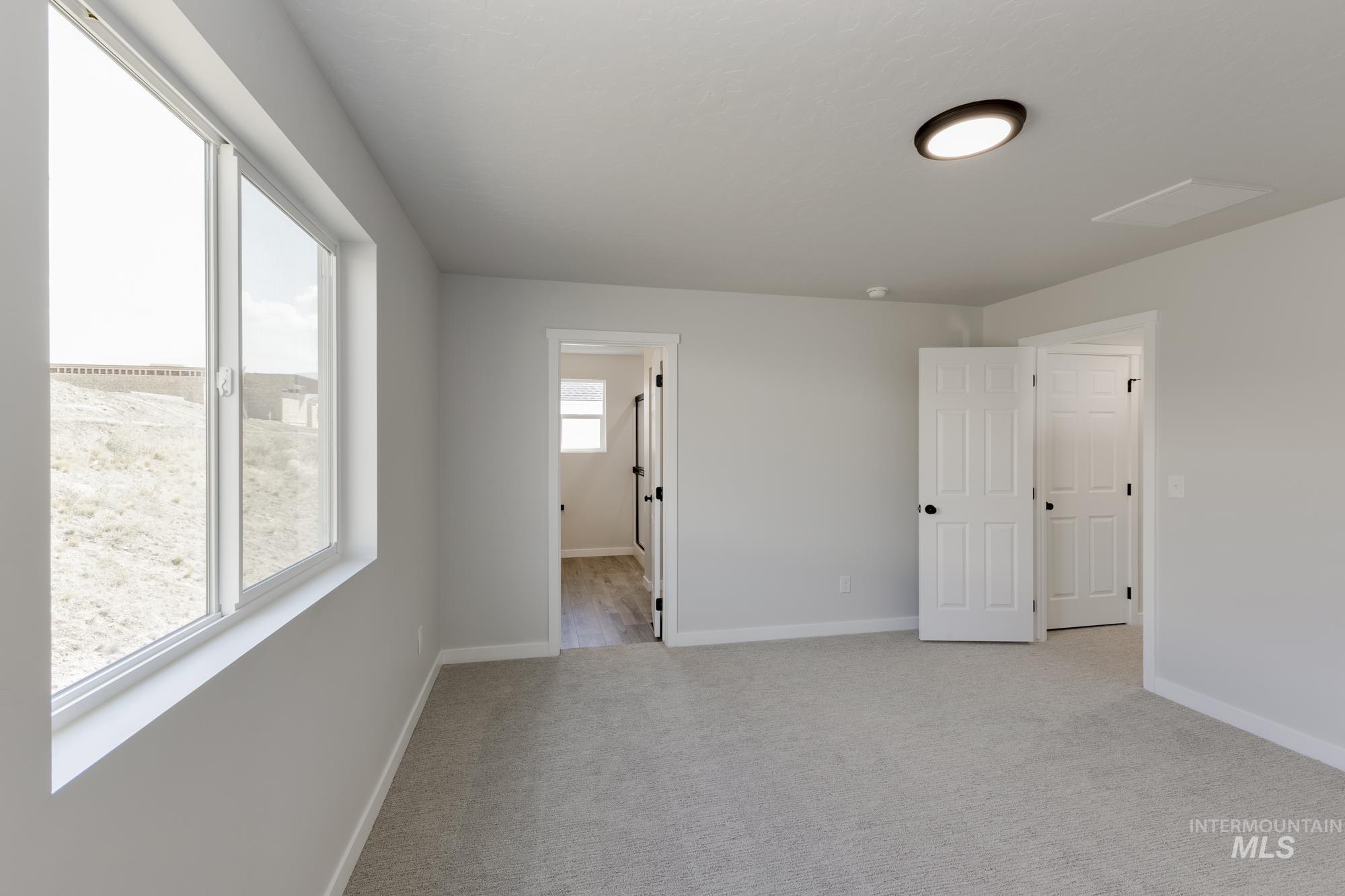 Unfurnished room with light colored carpet and baseboards