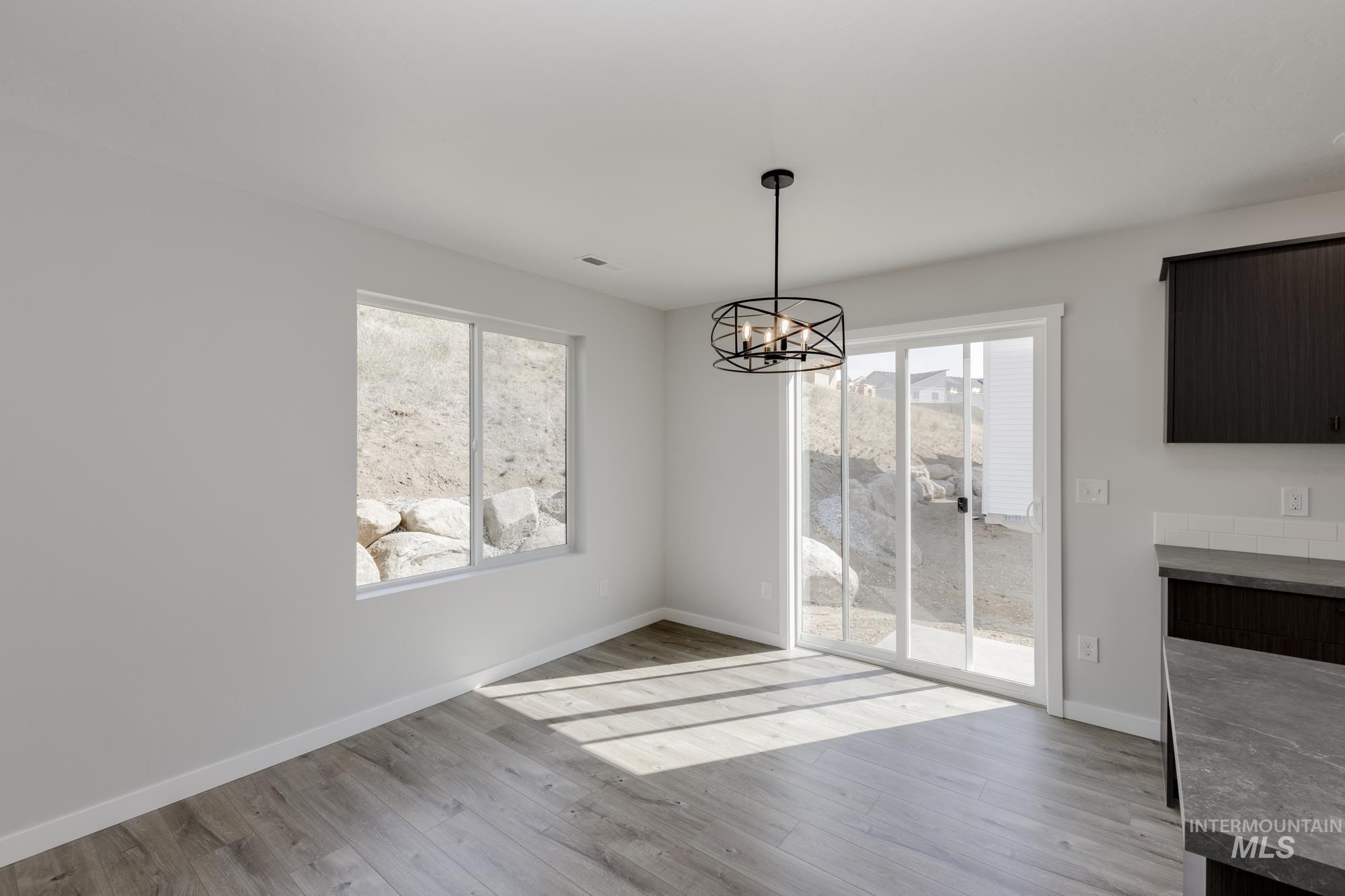 Unfurnished dining area featuring light wood-style floors and a chandelier