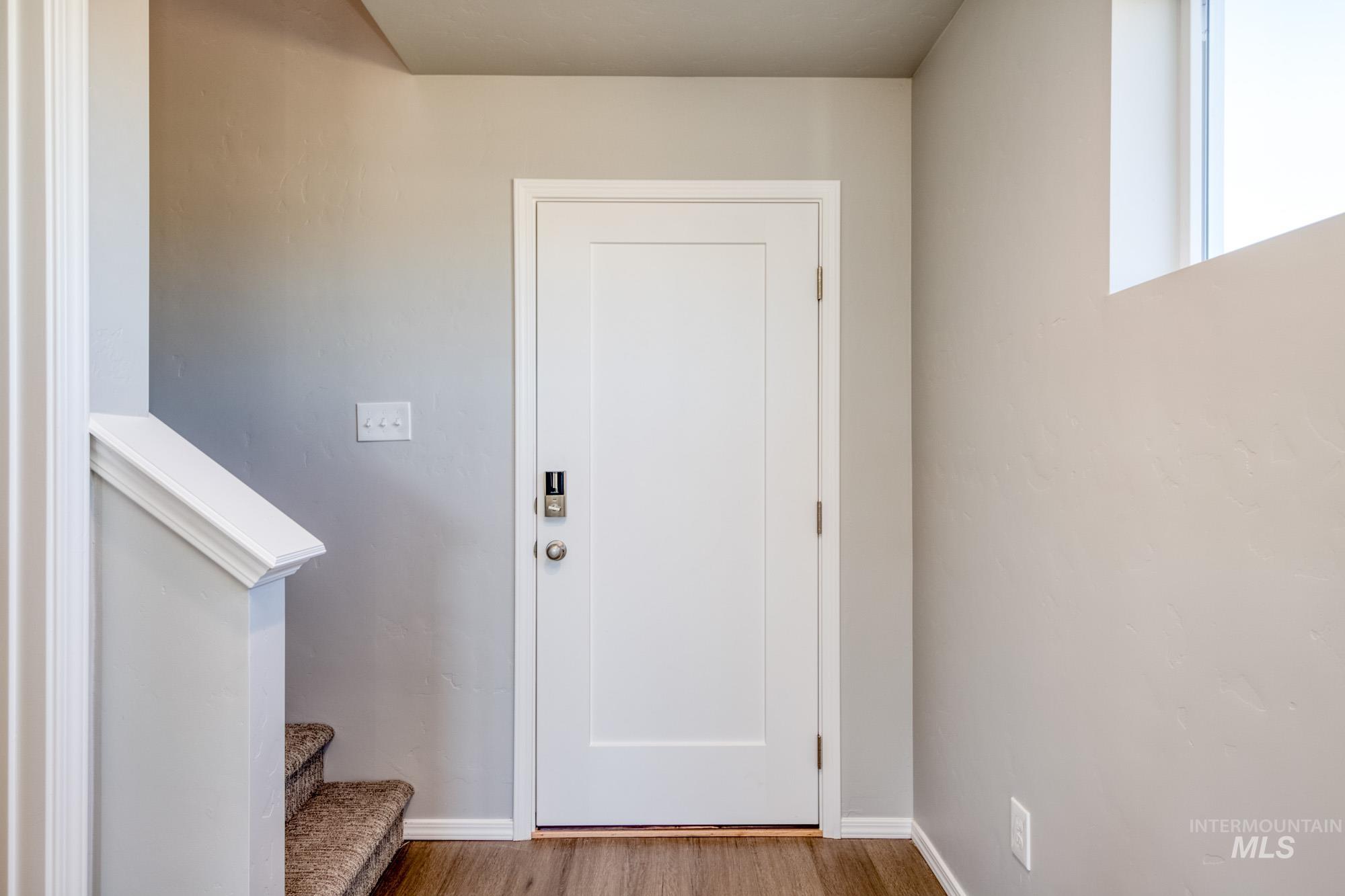 Entryway with stairs and wood finished floors