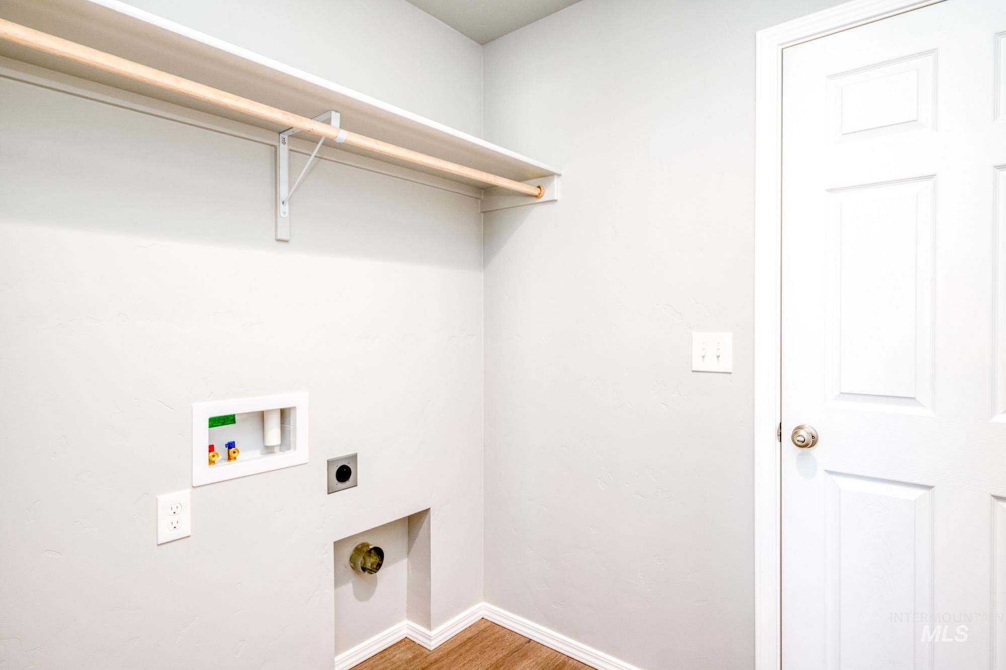 Washroom featuring light wood-style floors, electric dryer hookup, and hookup for a washing machine