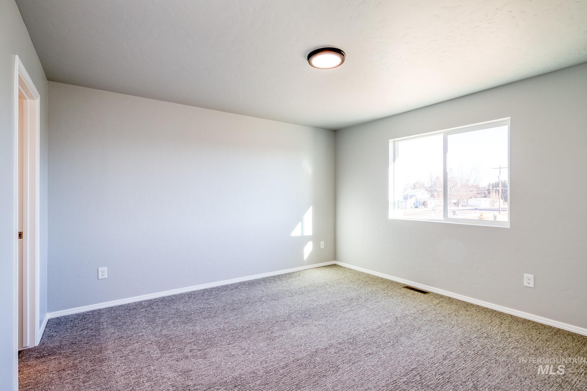Unfurnished room with baseboards and carpet