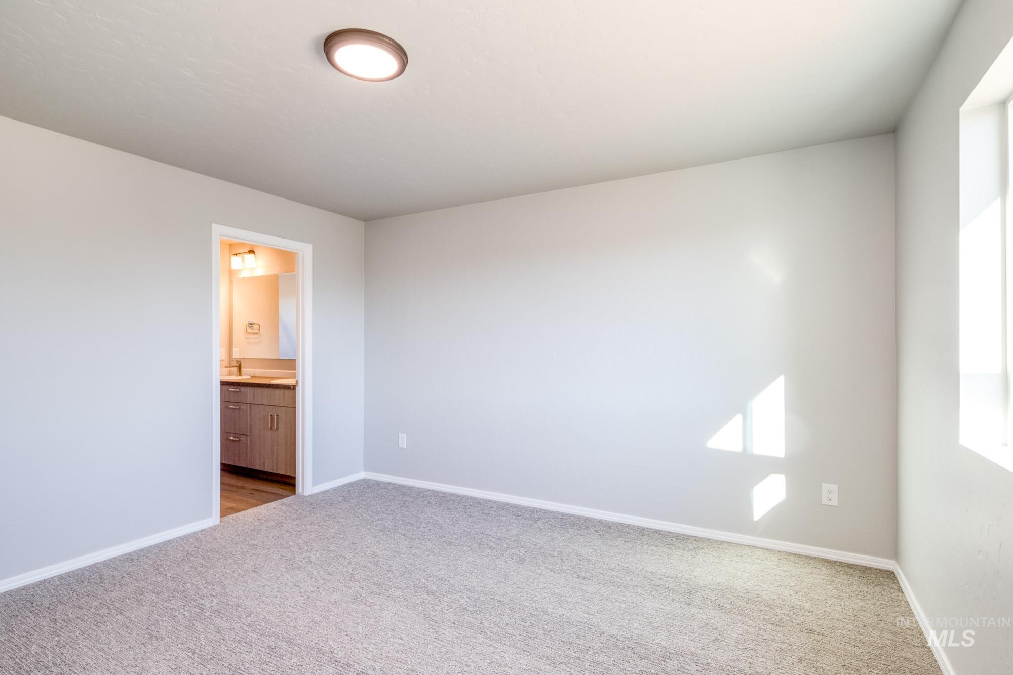 Unfurnished bedroom with carpet flooring and connected bathroom