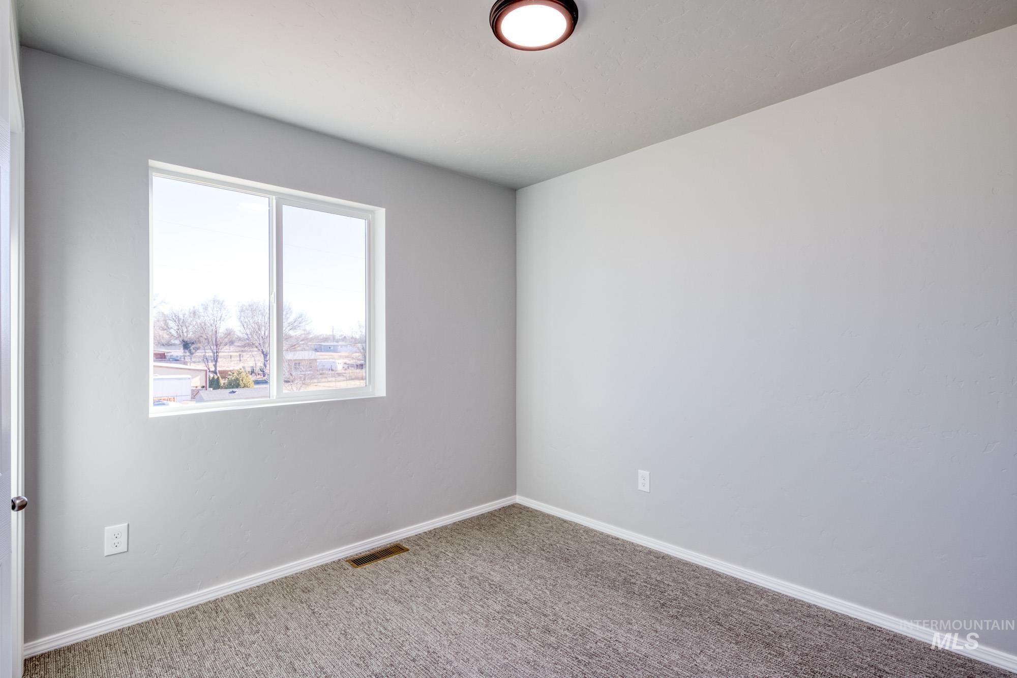 Empty room featuring baseboards and carpet flooring