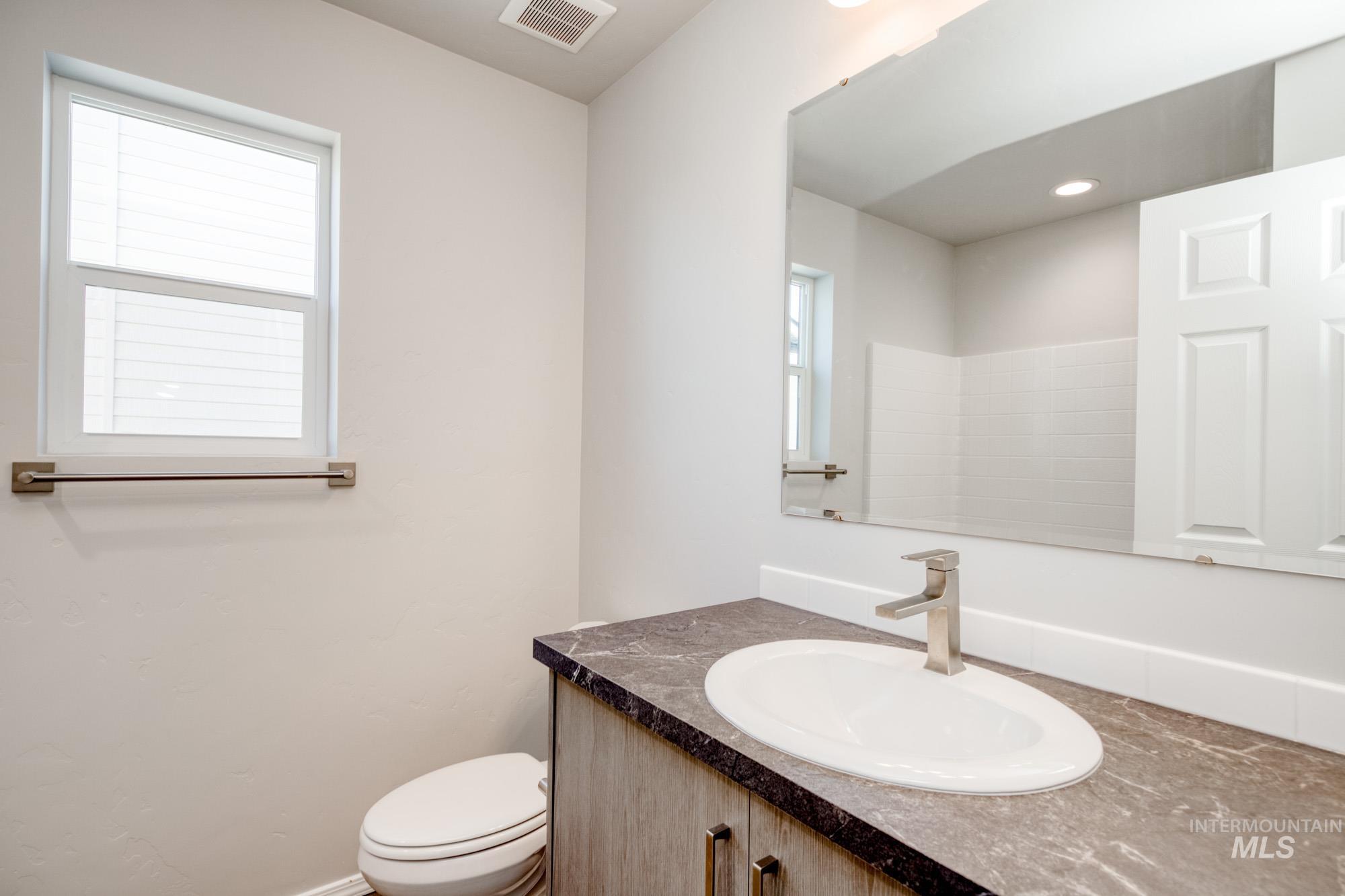 Bathroom featuring plenty of natural light and vanity