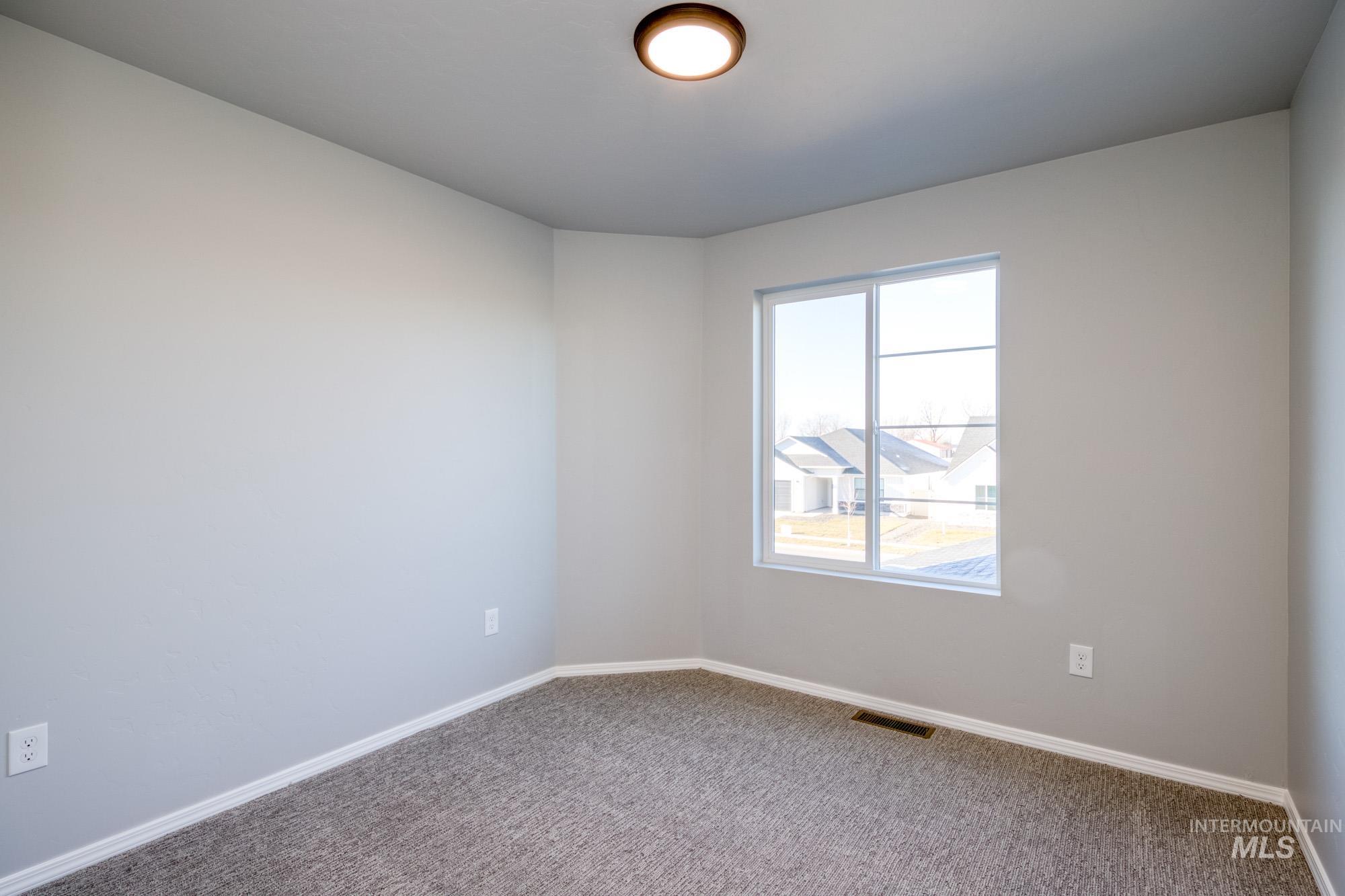 Carpeted empty room featuring baseboards