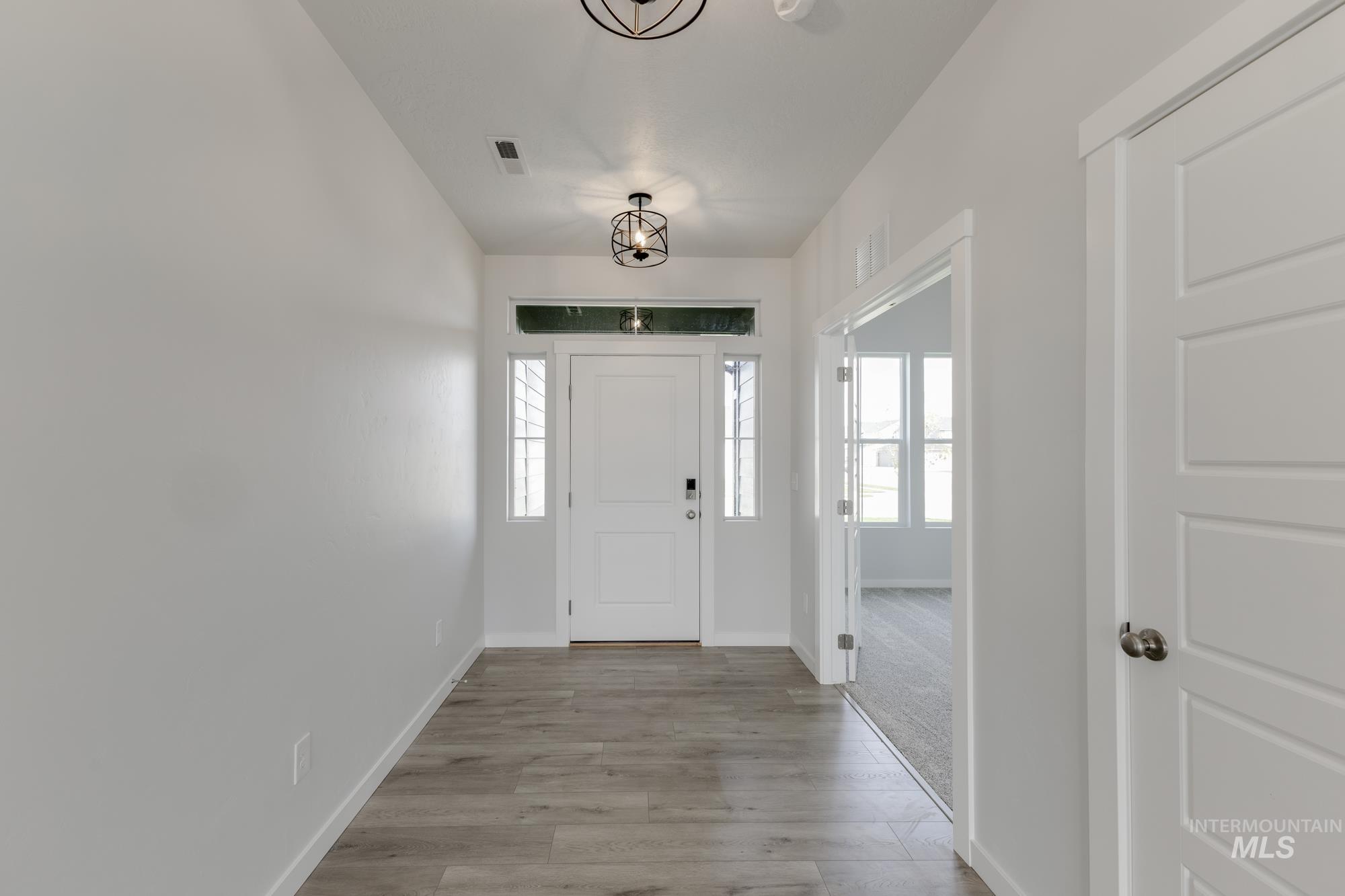 Foyer with baseboards and light wood-style flooring