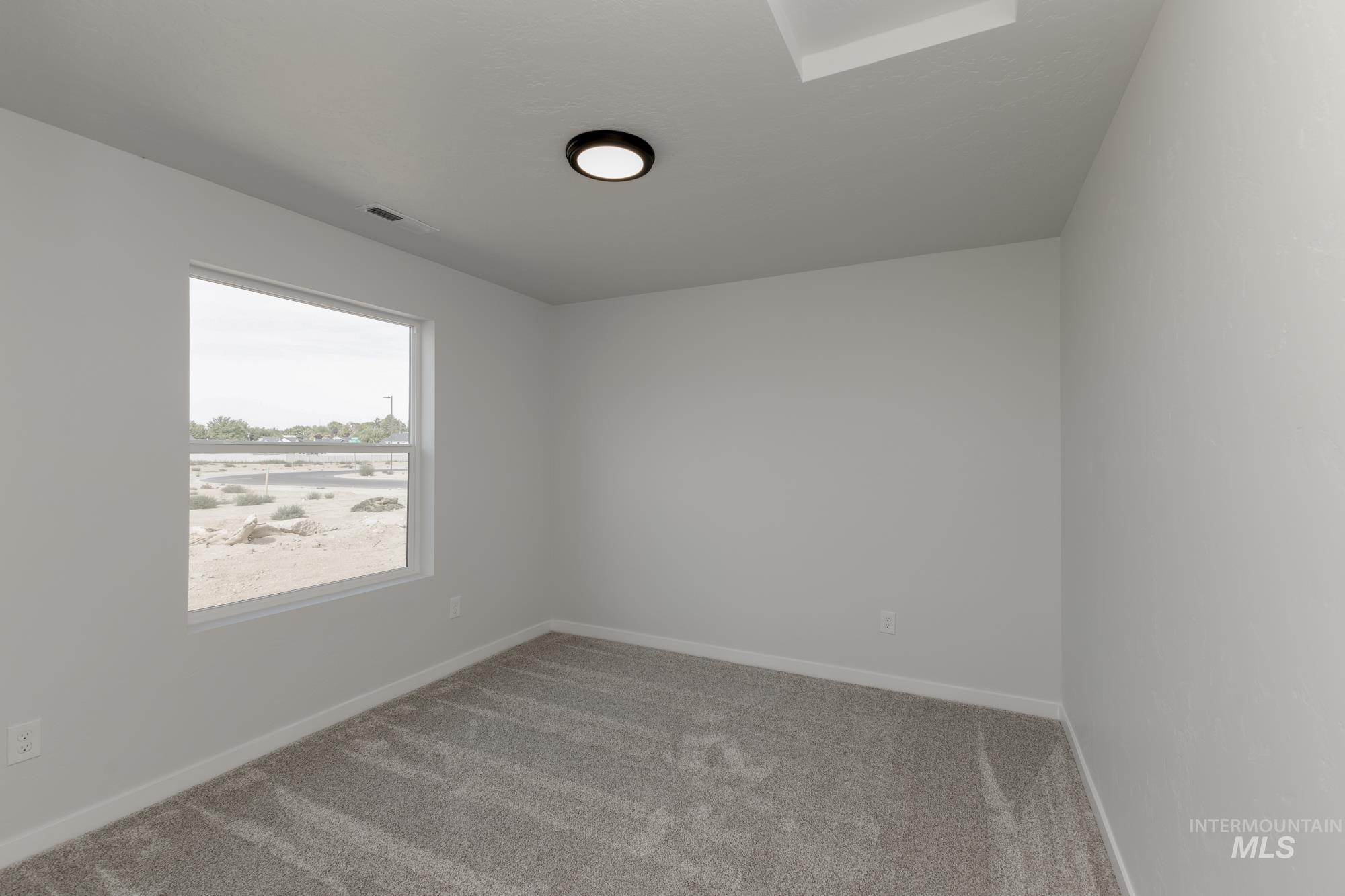 Unfurnished room featuring light carpet and baseboards