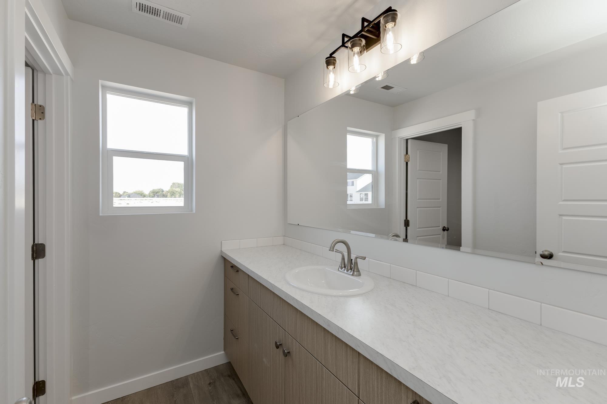 Half bath with vanity and dark wood-type flooring