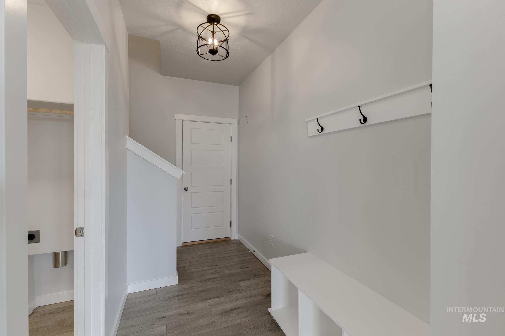 Mudroom featuring light wood-style floors and a chandelier