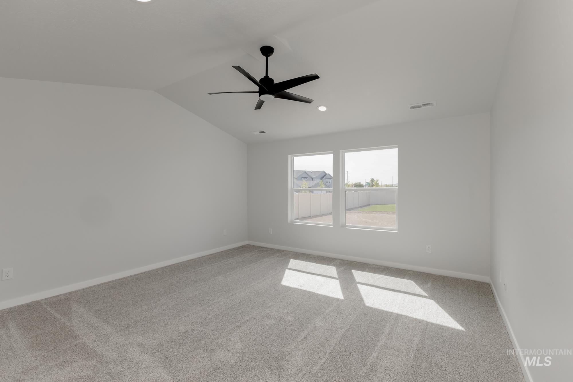Unfurnished room featuring light colored carpet, lofted ceiling, a ceiling fan, and recessed lighting