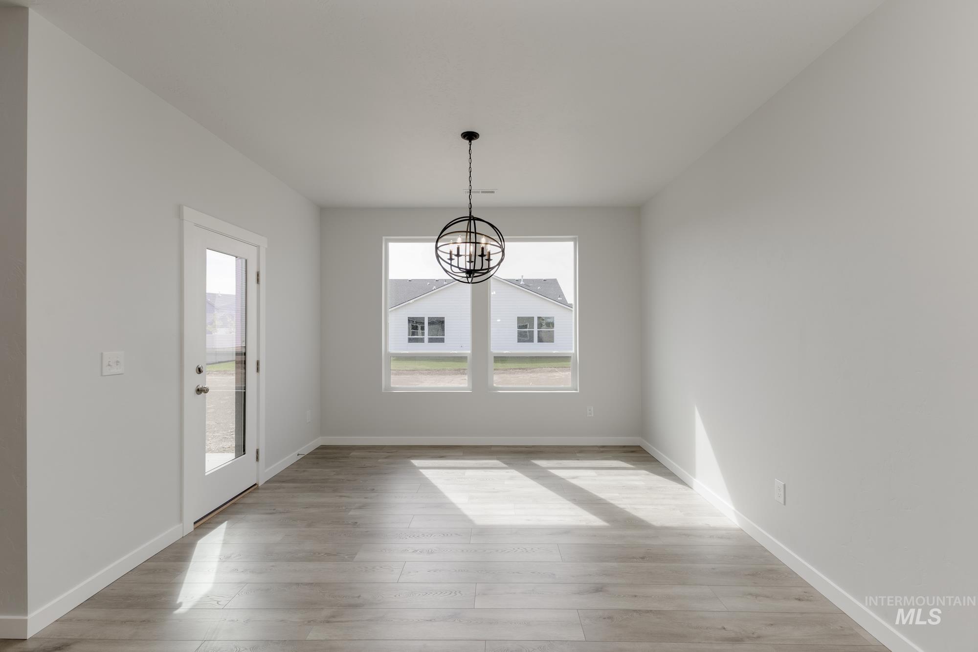 Unfurnished dining area featuring light wood-style floors and a chandelier
