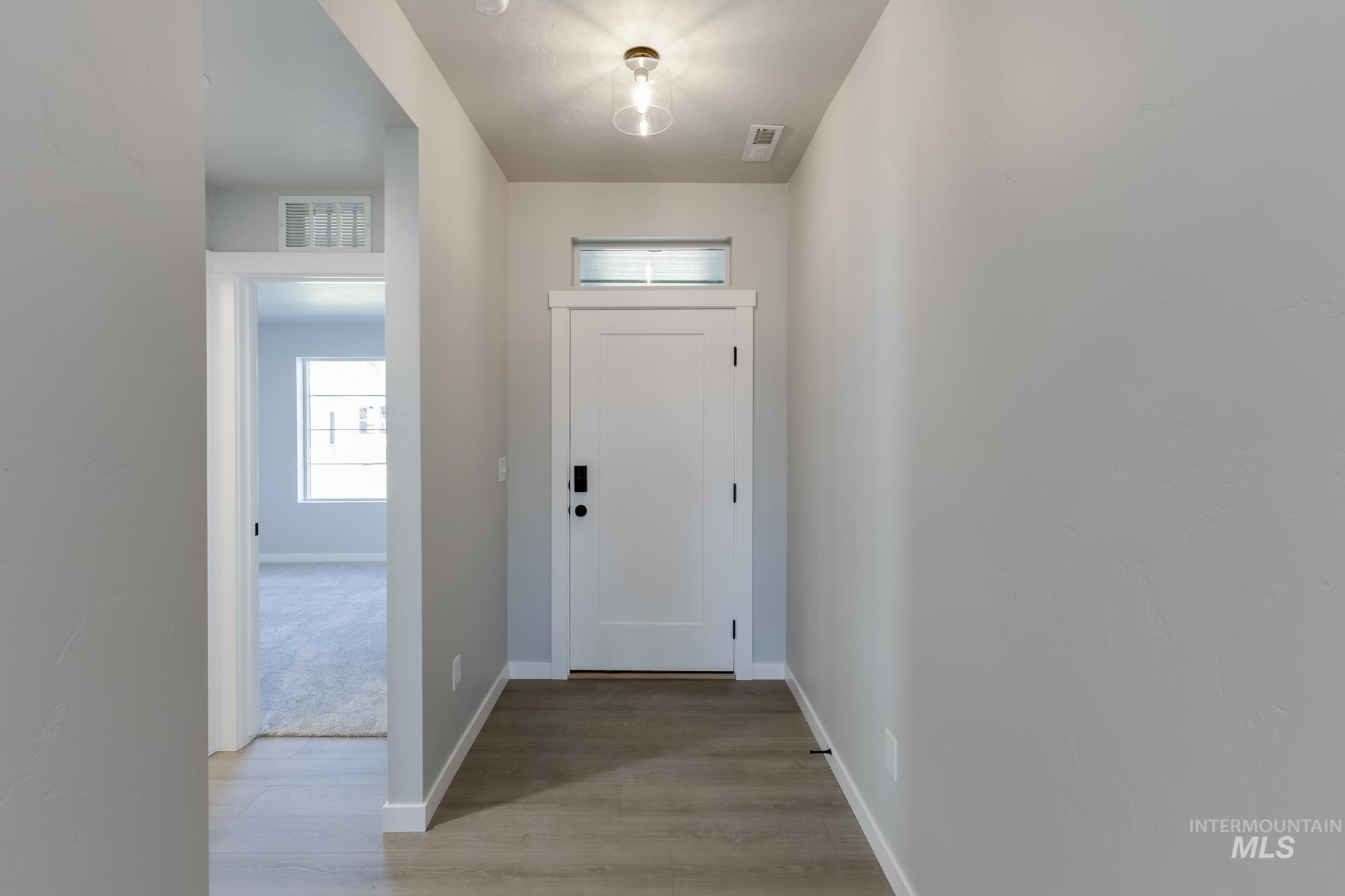 Entryway featuring baseboards and light wood finished floors