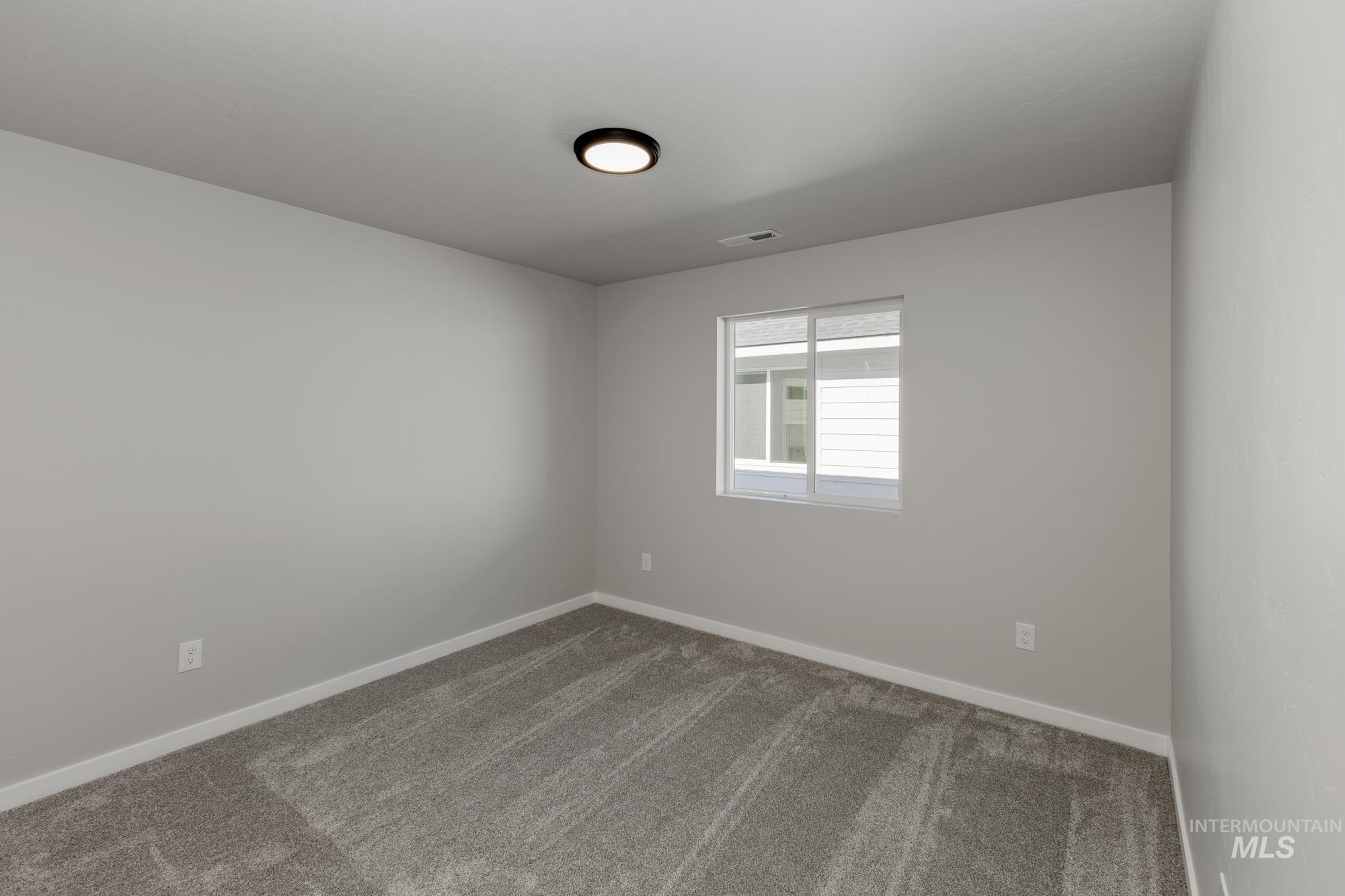 Carpeted empty room with baseboards