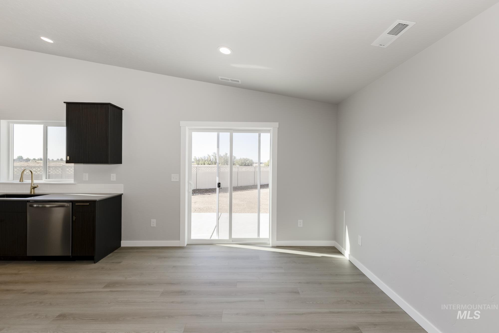 Unfurnished dining area featuring light wood-style flooring, recessed lighting, and vaulted ceiling