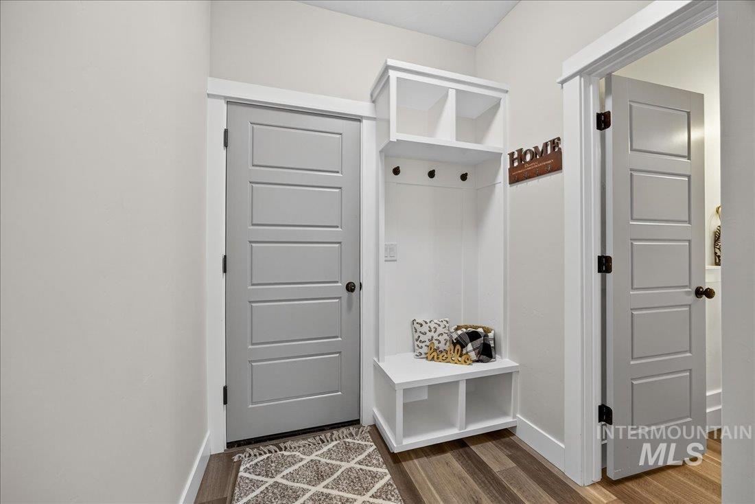 Mudroom featuring dark wood-type flooring and baseboards