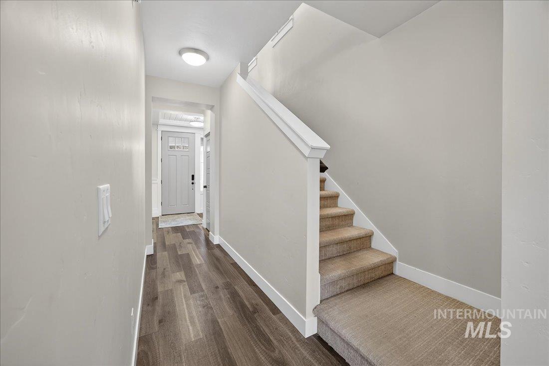 Foyer entrance with stairs and dark wood-style flooring
