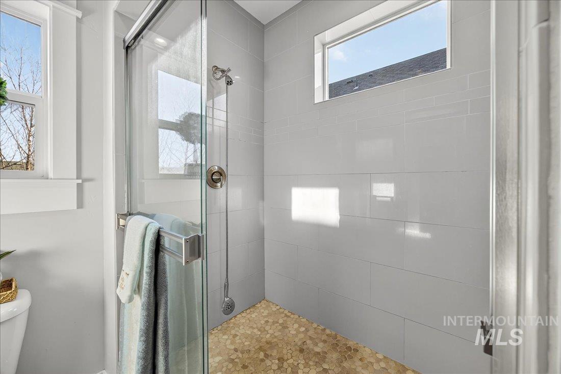 Full bath with a shower stall and toilet