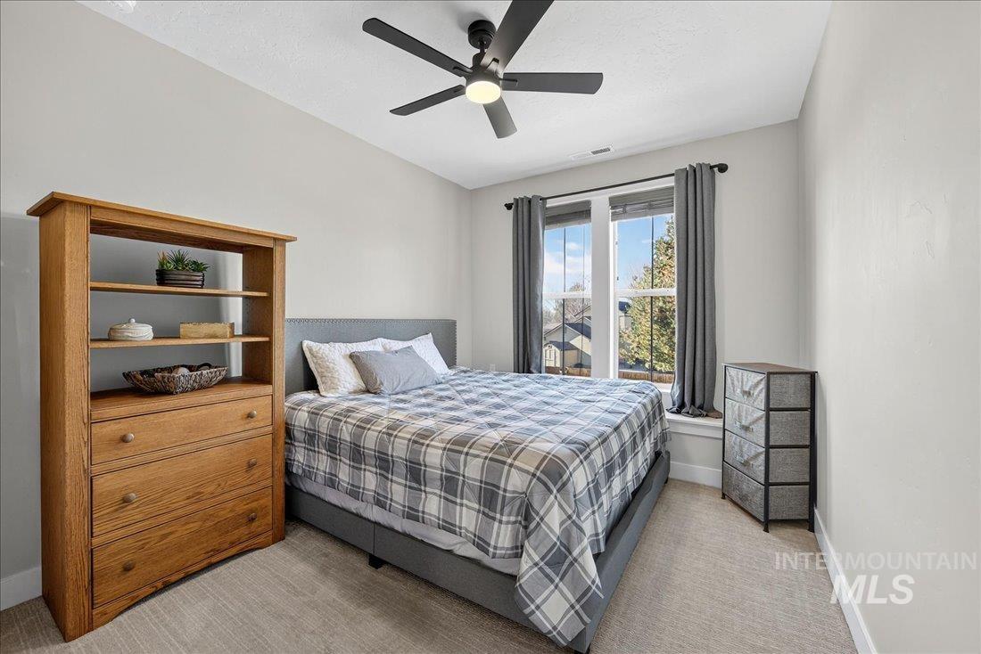 Bedroom featuring ceiling fan and light carpet