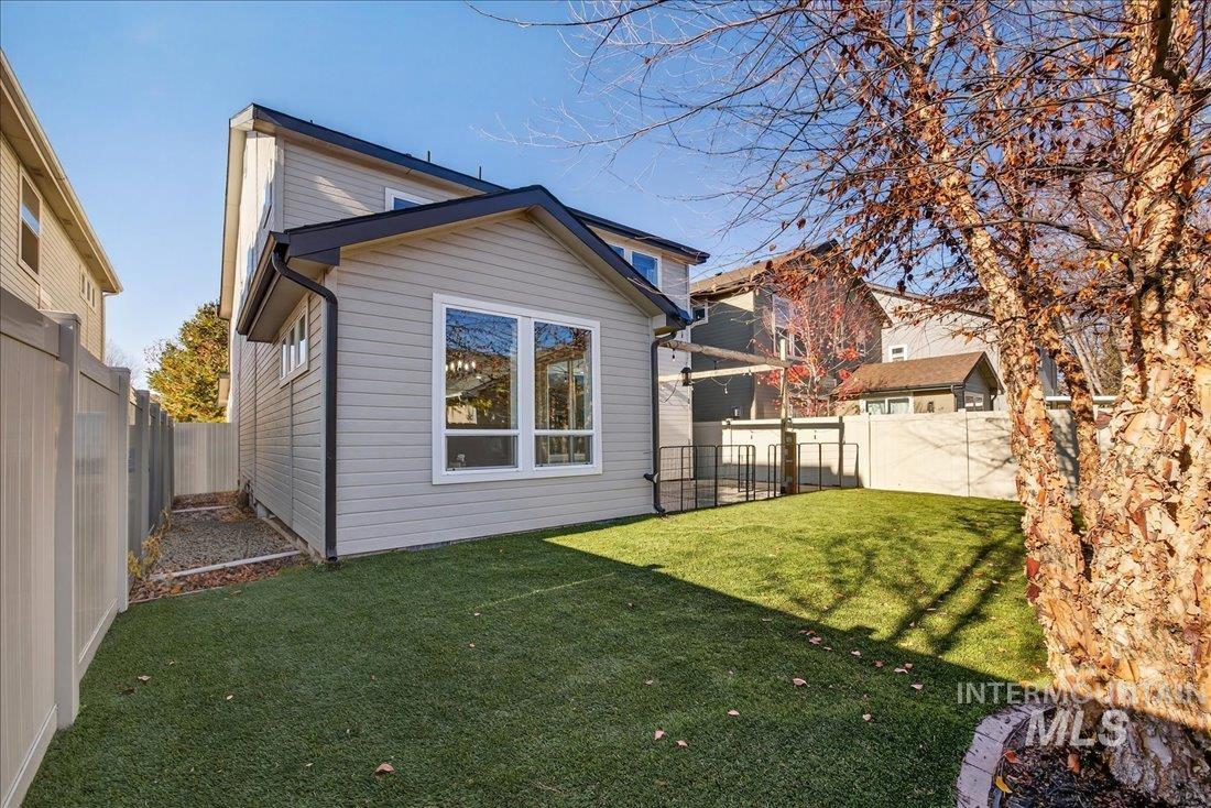 Rear view of house featuring a fenced backyard