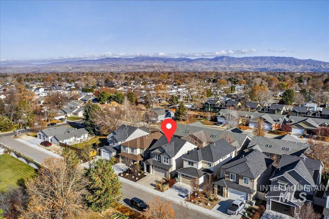 Aerial overview of property's location with a mountain backdrop and nearby suburban area
