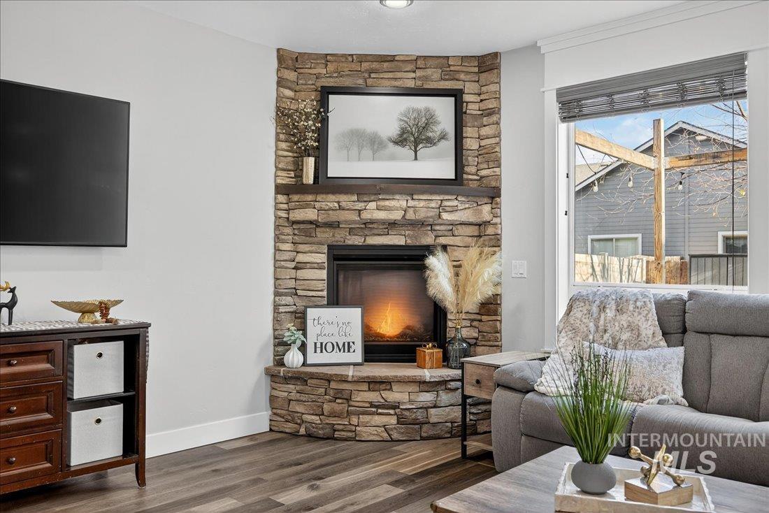 Living area with a stone fireplace and wood finished floors