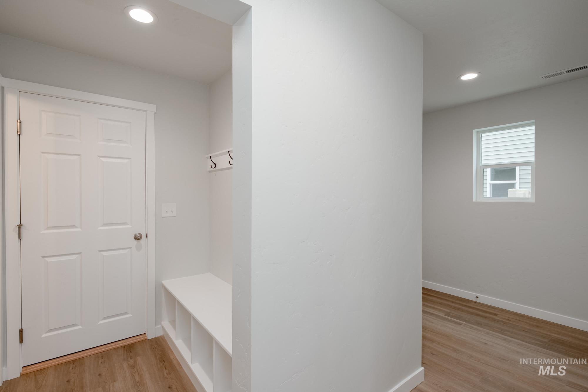 Mudroom with recessed lighting and light wood-style floors