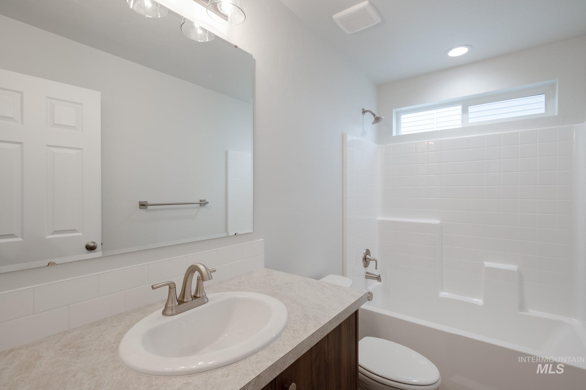 Full bathroom with shower / tub combination, vanity, and backsplash