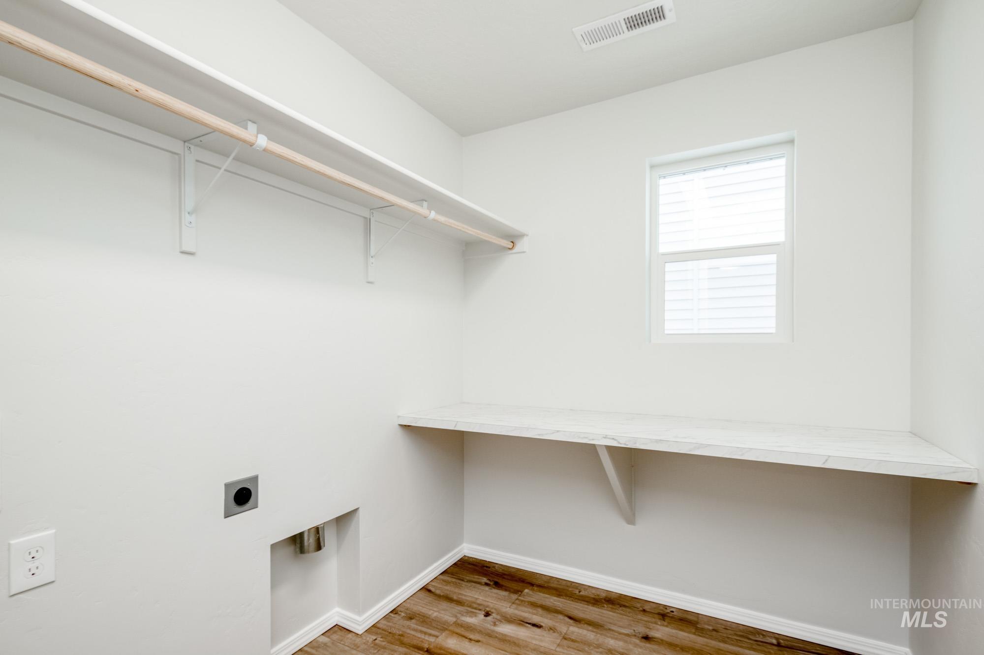Laundry room featuring light wood-style flooring and electric dryer hookup